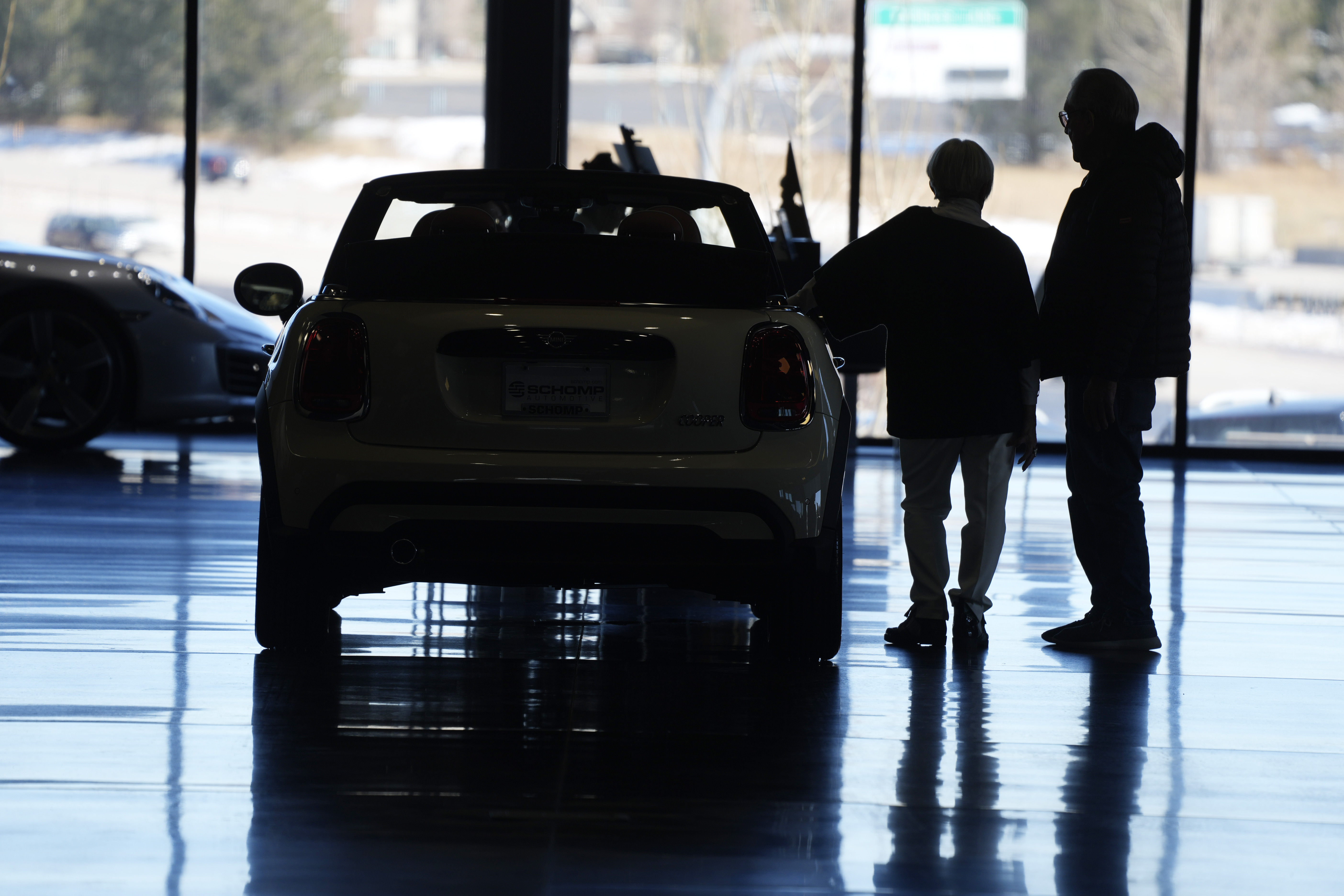 Car shoppers consider a 2022 Cooper convertible on display in a Mini dealership in Highlands Ranch, Colo., on Friday. A low credit score can hurt your ability to take out a loan, secure a good interest rate, or increase a credit card spending limit. 