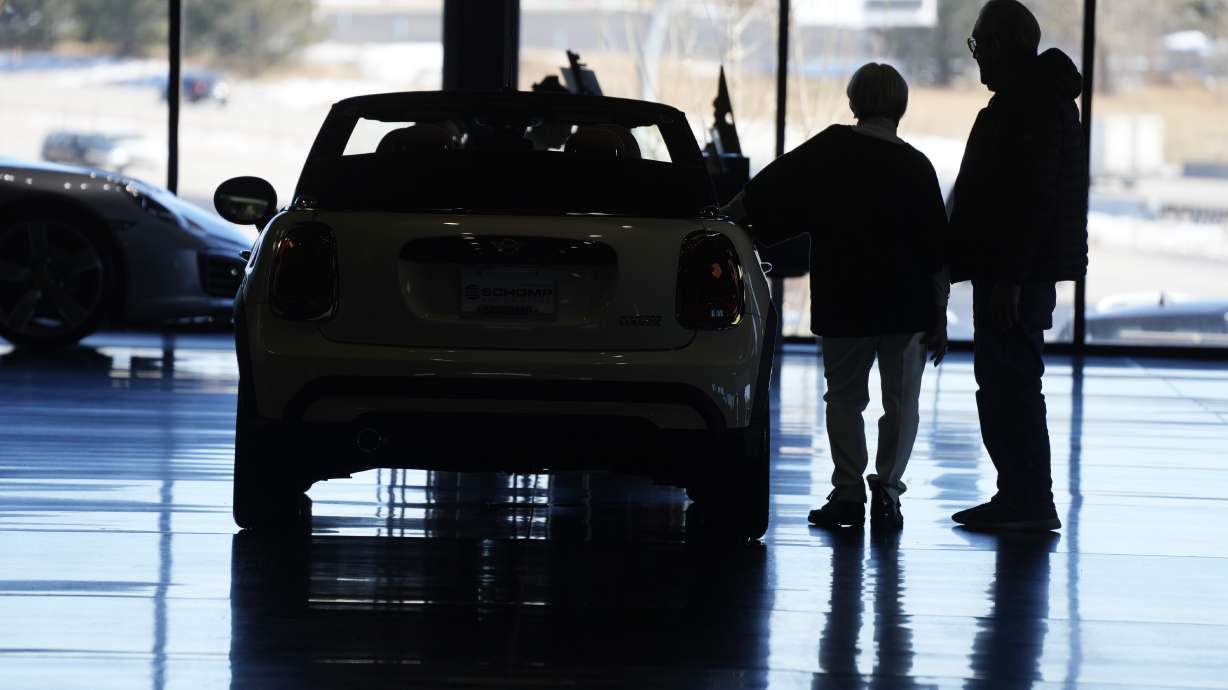 Car shoppers consider a 2022 Cooper convertible on display in a Mini dealership in Highlands Ranch, Colo., on Friday. A low credit score can hurt your ability to take out a loan, secure a good interest rate, or increase a credit card spending limit.