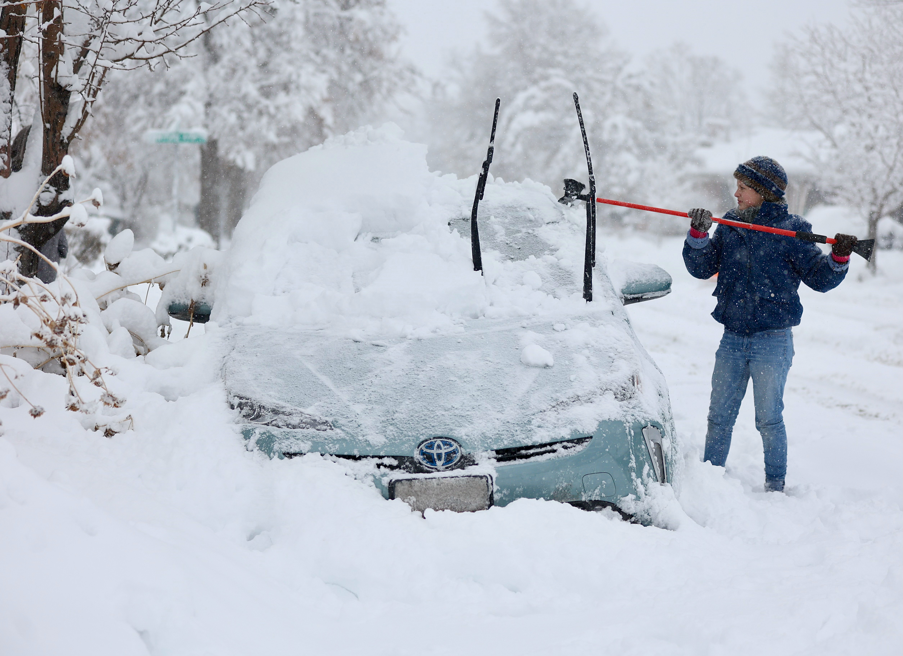 Cathy Morgan-Mace cleans off her family’s car in Salt Lake City during a winter storm on Feb. 22.