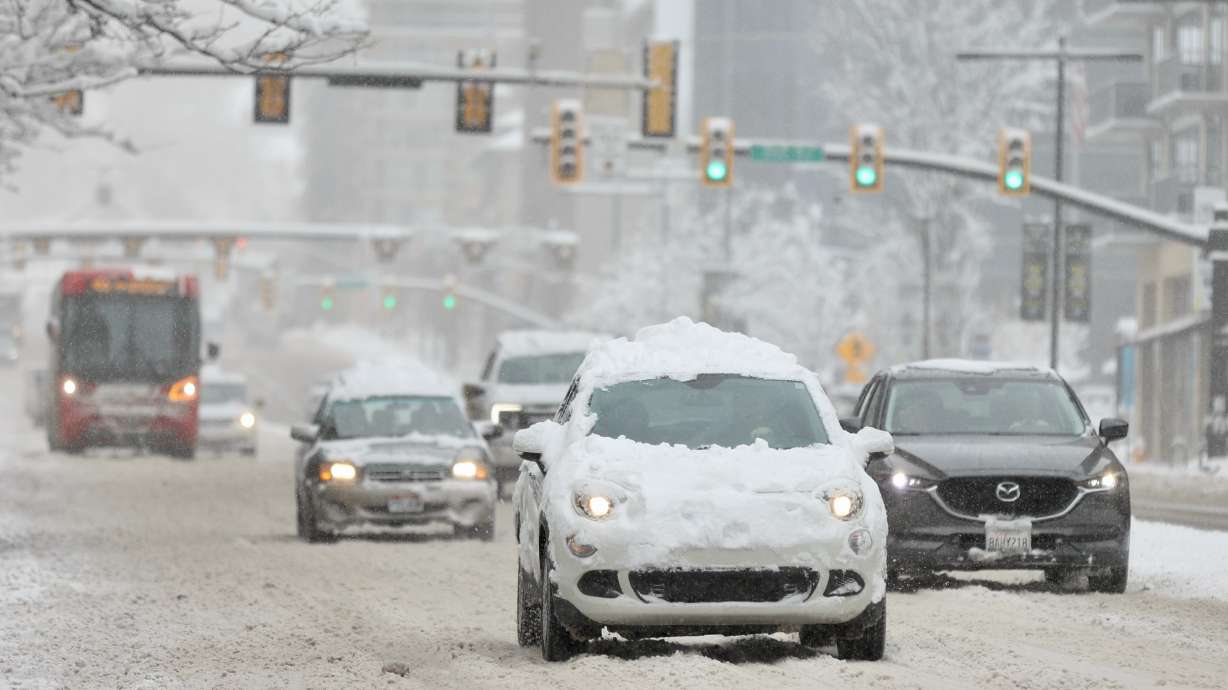 Cars drive on State Street in Salt Lake City during a winter storm on Wednesday. Utah Highway Patrol troopers say they arrested an impaired driver who was driving the wrong way on I-80 during Wednesday morning's snowstorm and doing doughnuts on the freeway.