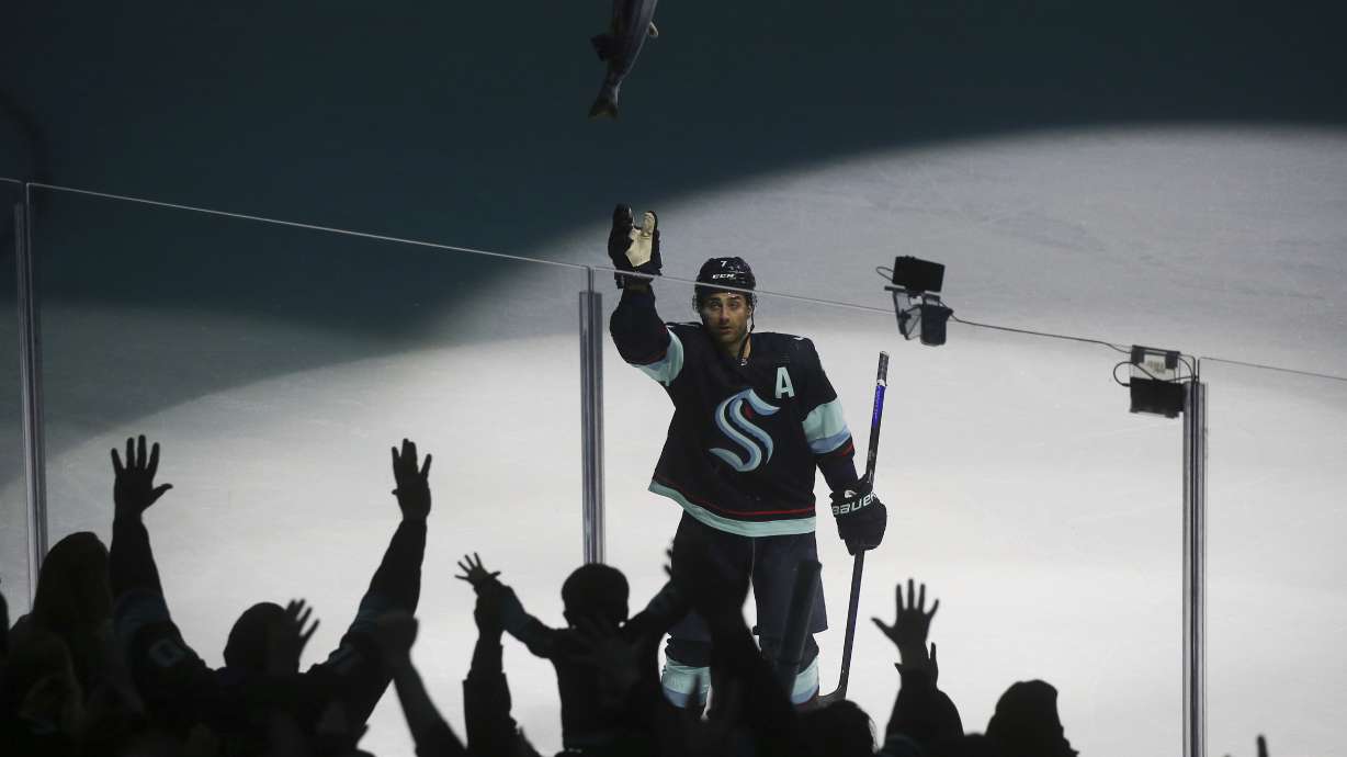 Seattle Kraken right wing Jordan Eberle (7) throws a stuffed salmon to fans as they celebrate the Kraken's 4-2 win against the Detroit Red Wings in an NHL hockey game Saturday, Feb. 18, 2023, in Seattle.