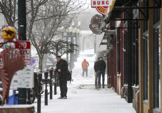Pedestrians stand as snow falls around them ahead of a winter storm on Tuesday in Sioux Falls, S.D. A wide swath of the Upper Midwest is bracing for a historic winter storm. The system is expected to bury parts of the region in 2 feet of snow, create dangerous blizzard conditions and bring along bitter cold temperatures.