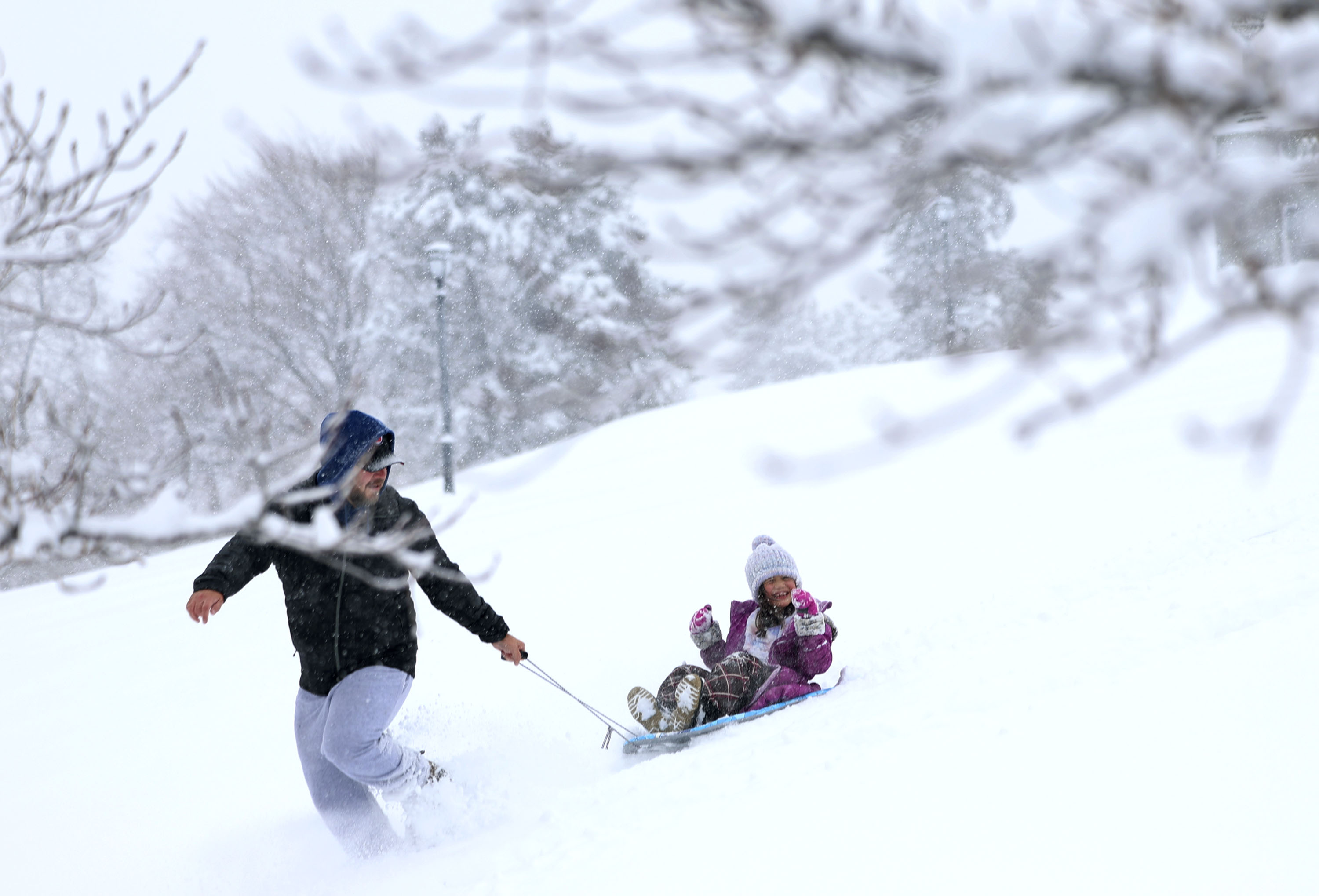 Nick Tate pulls his daughter, Lily, 7, on a sled at the Capitol in Salt Lake City on Wednesday. Utah's statewide snowpack received a significant boost as a result of the record-breaking storm system that impacted all of Utah this week.