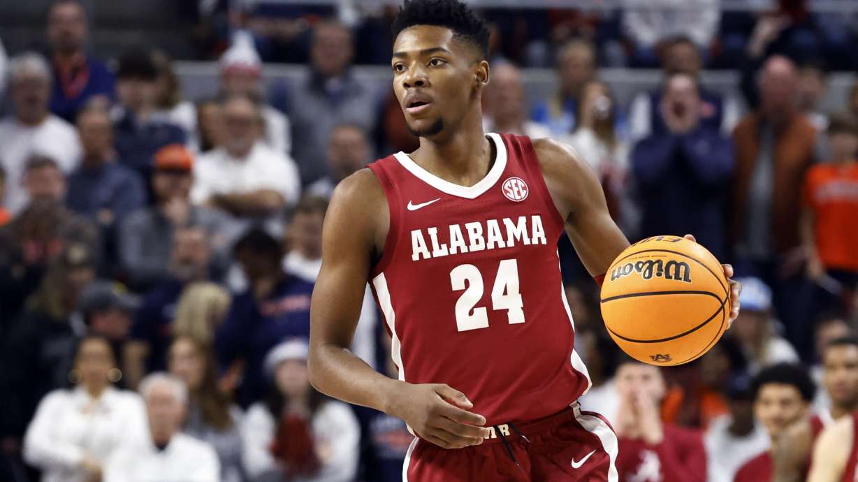 FILE - Alabama forward Brandon Miller brings the ball up during the first half of the team's NCAA college basketball game against Auburn on Feb. 11, 2023, in Auburn, Ala. Police say Miller brought a teammate the gun that was used in a fatal shooting near campus. Tuscaloosa Police investigator Brandon Culpepper testified during a preliminary hearing Tuesday, Feb. 21, that Miller brought Darius Miles’ gun to him on the night of the shooting after Miles texted him and asked him to do so.