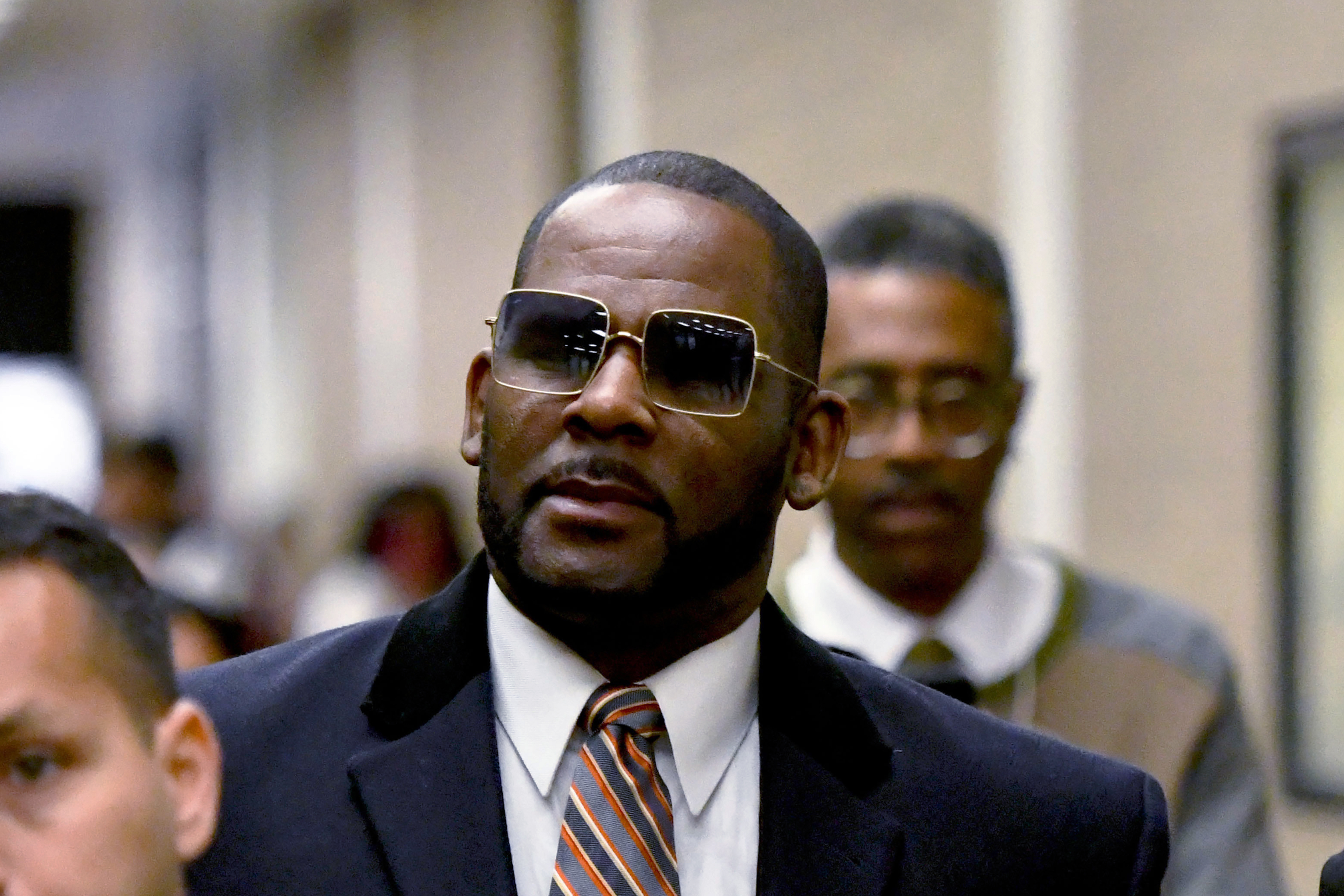R. Kelly, center, leaves the Daley Center after a hearing in his child support case May 8, 2019, in Chicago. A federal judge has handed singer R. Kelly a 20-year prison sentence for new convictions.
