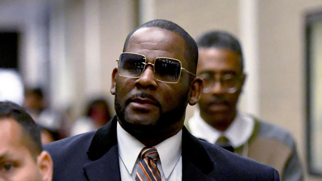 R. Kelly, center, leaves the Daley Center after a hearing in his child support case May 8, 2019, in Chicago. A federal judge has handed singer R. Kelly a 20-year prison sentence for new convictions.