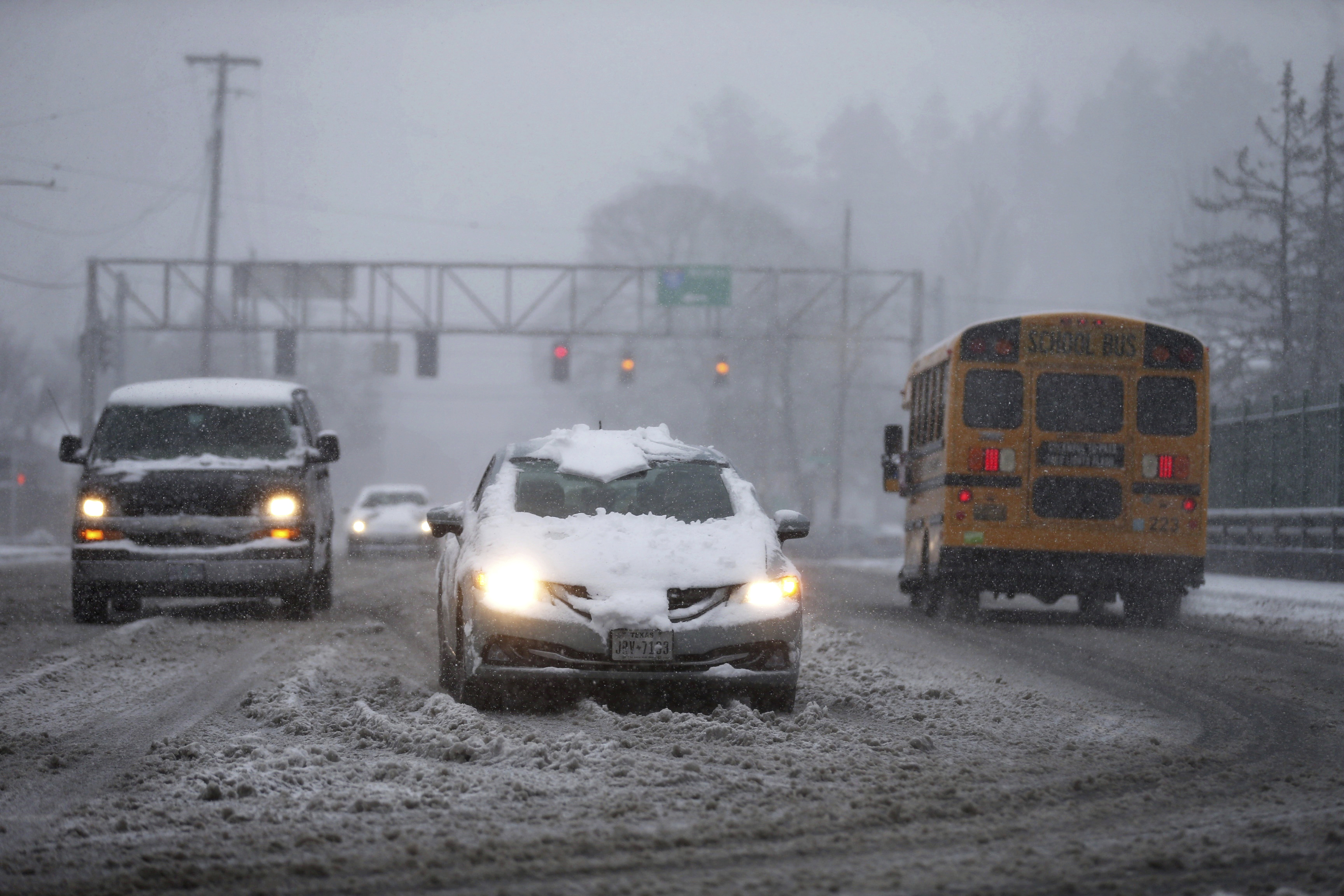 Vehicles drive on the Rosa Parks overpass at I-5 during a snowstorm on Wednesday, in Portland, Ore. A brutal winter storm is poised to slam California Thursday.