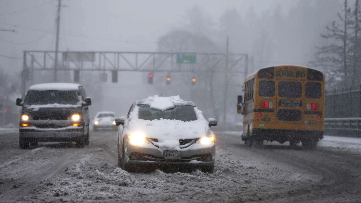 Vehicles drive on the Rosa Parks overpass at I-5 during a snowstorm on Wednesday, in Portland, Ore. A brutal winter storm is poised to slam California Thursday.
