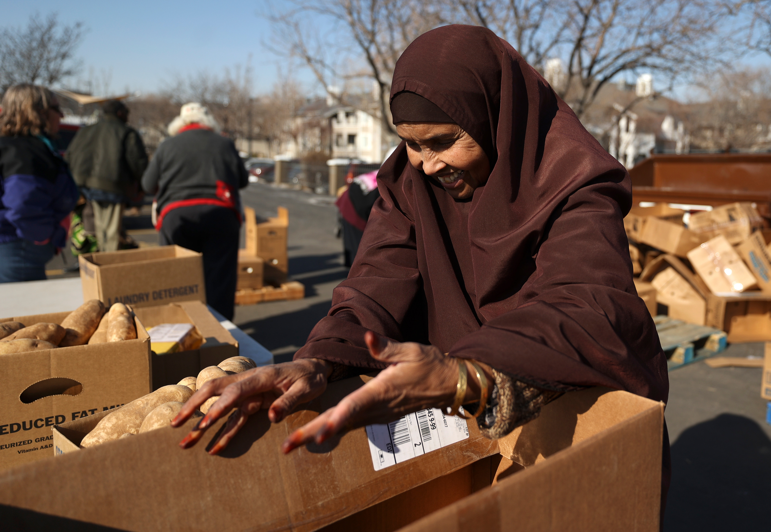 Volunteer Anab Awale helps prepare a box of food at a food bank outside of University Neighborhood Partners Hartland Partnership Center in Salt Lake City on Feb. 1.