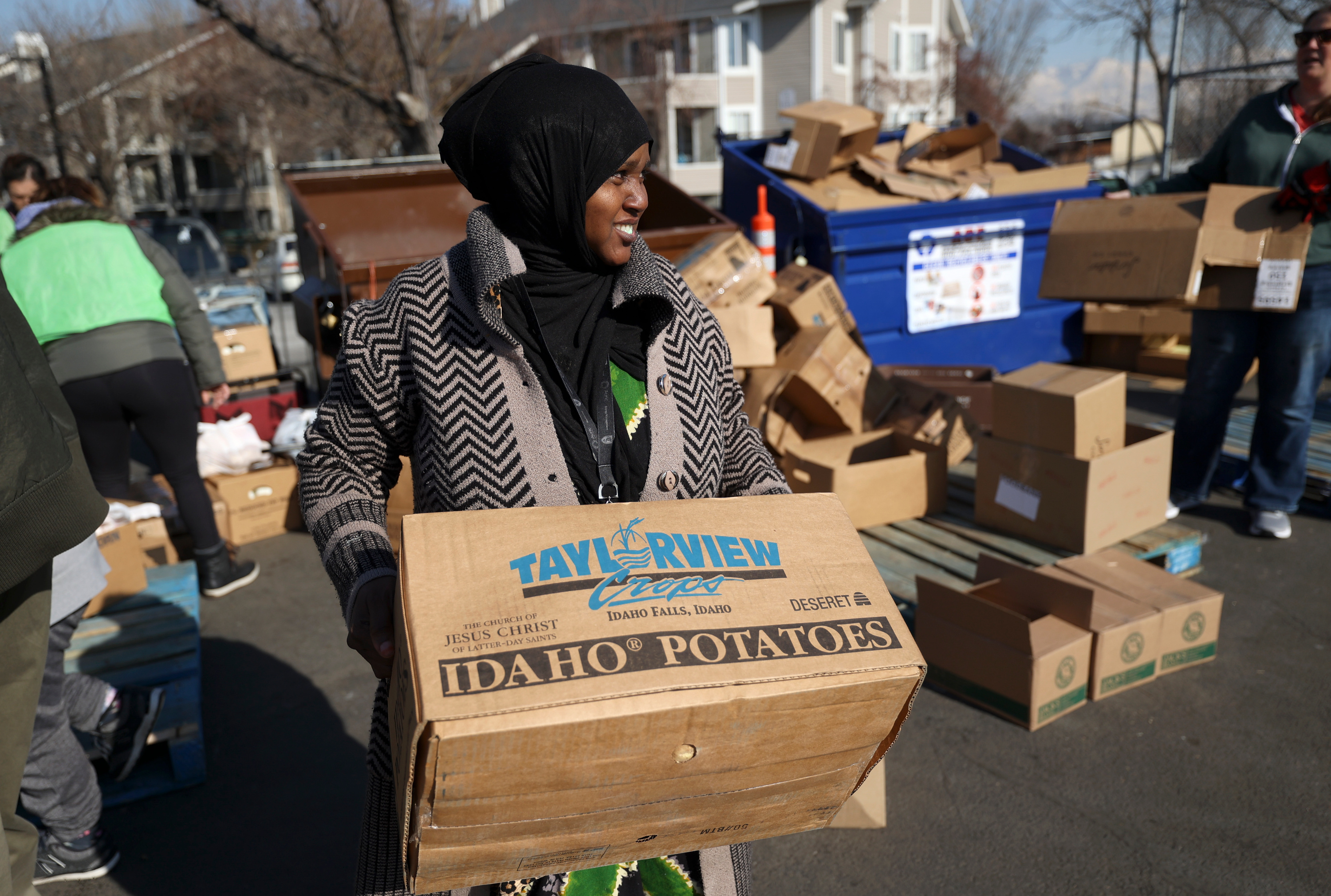 Volunteer Sacdiya Mohamed carries a box of food at a food bank, organized by the Somali Community Self-Management Agency, Salt Lake American Refugee Services and University Neighborhood Partners, outside of University Neighborhood Partners Hartland Partnership Center in Salt Lake City, on Feb. 1.