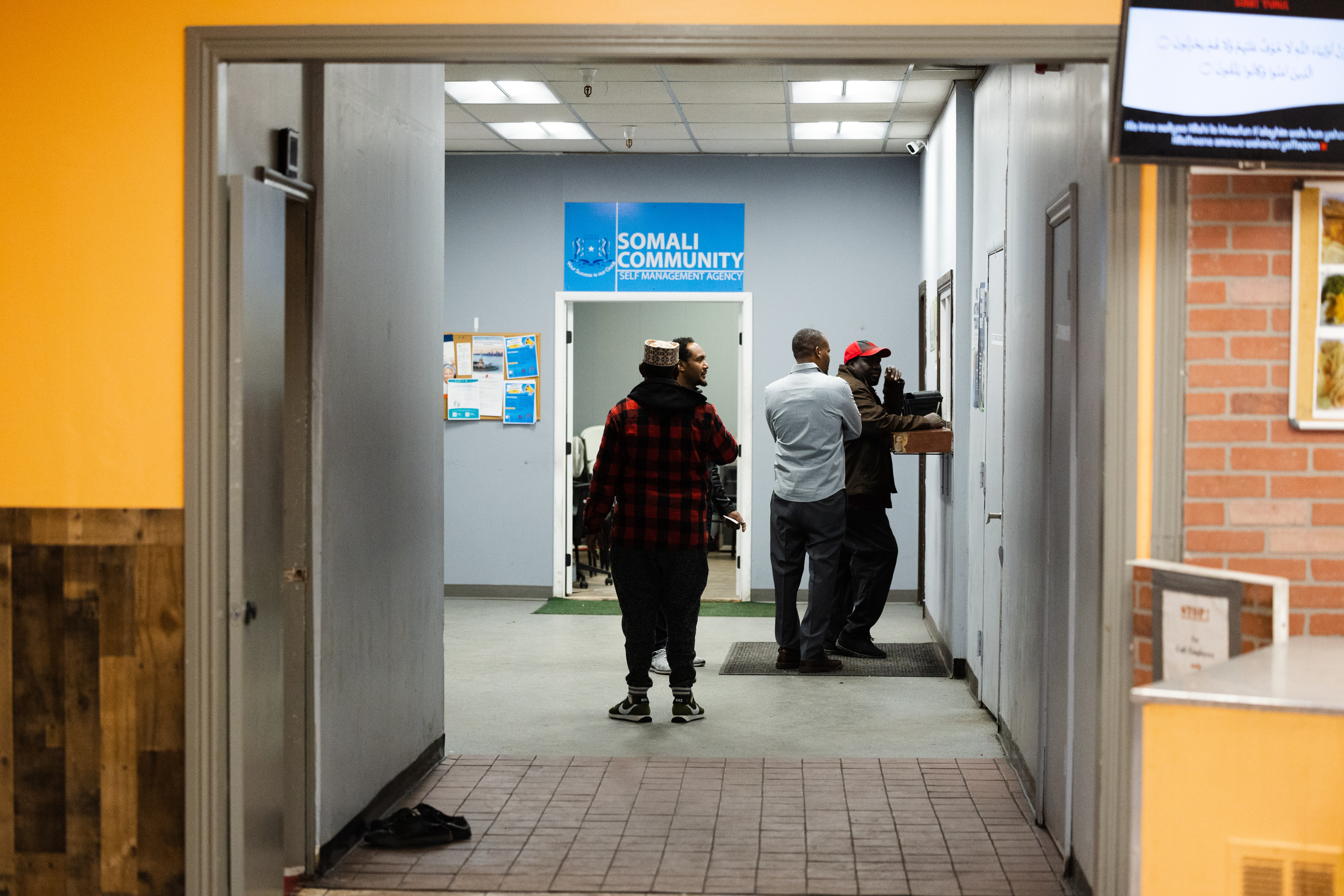 People gather around outside the Somali Community Self-Management Agency in Salt Lake City on Jan. 26. The agency is located inside a Somali mini mall, where services range from a restaurant and mosque to a clothing boutique and money exchange office.