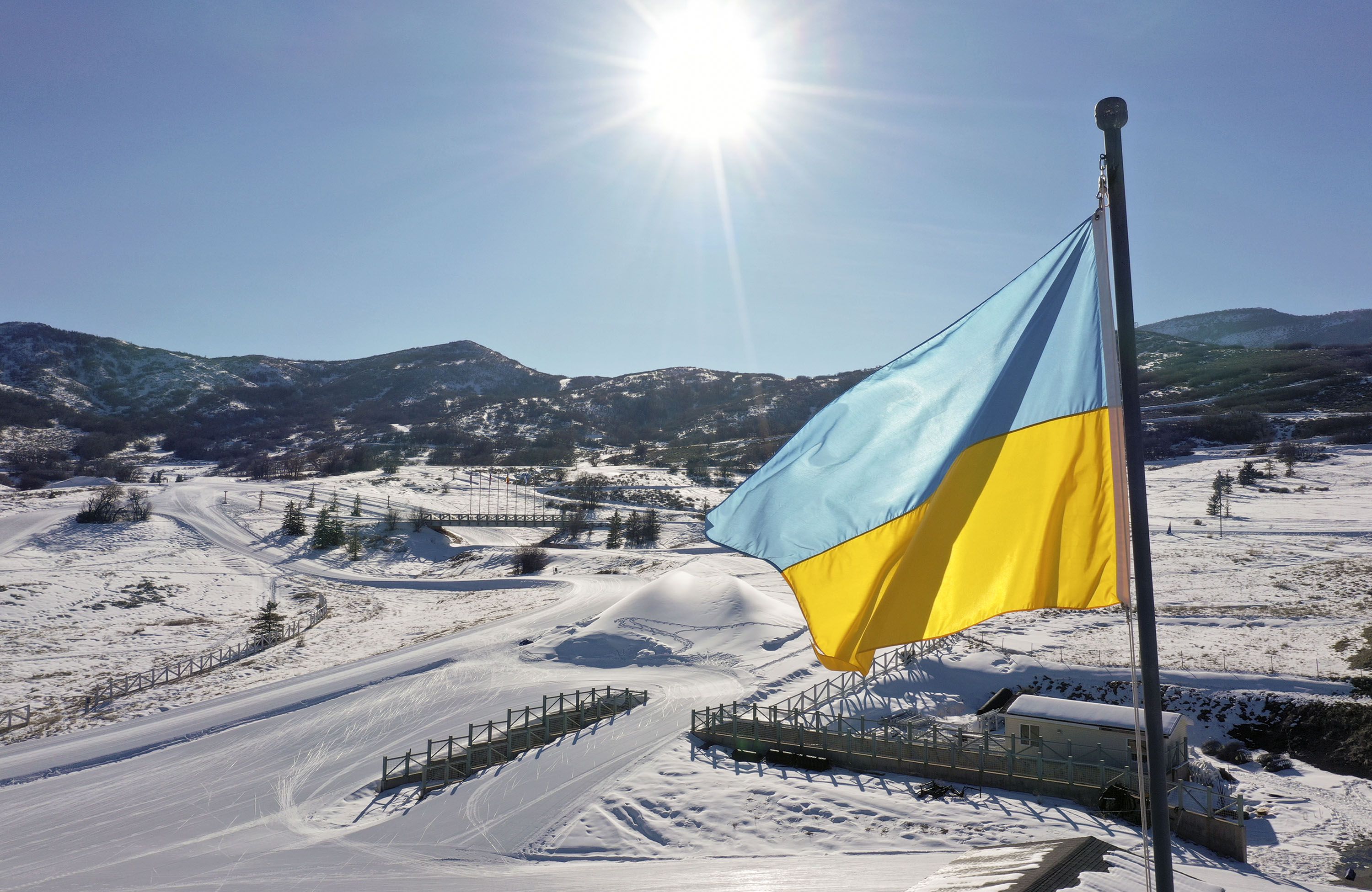 A Ukrainian flag waves in the wind over the Soldier Hollow Nordic Center for the 2022 Biathlon Youth and Junior World Championships in Midway on Feb. 28, 2022. The flag was flown in place of the International Biathlon Union flag.
