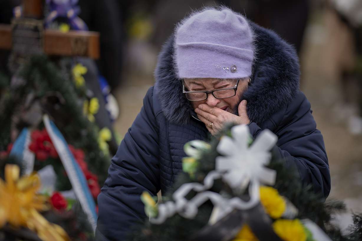 Maria Kurbet, 77, cries at the grave of her son, a military serviceman killed in Bakhmut, during a memorial service to mark the one-year anniversary of the start of the Russia-Ukraine war, in Bucha, Ukraine, Friday.