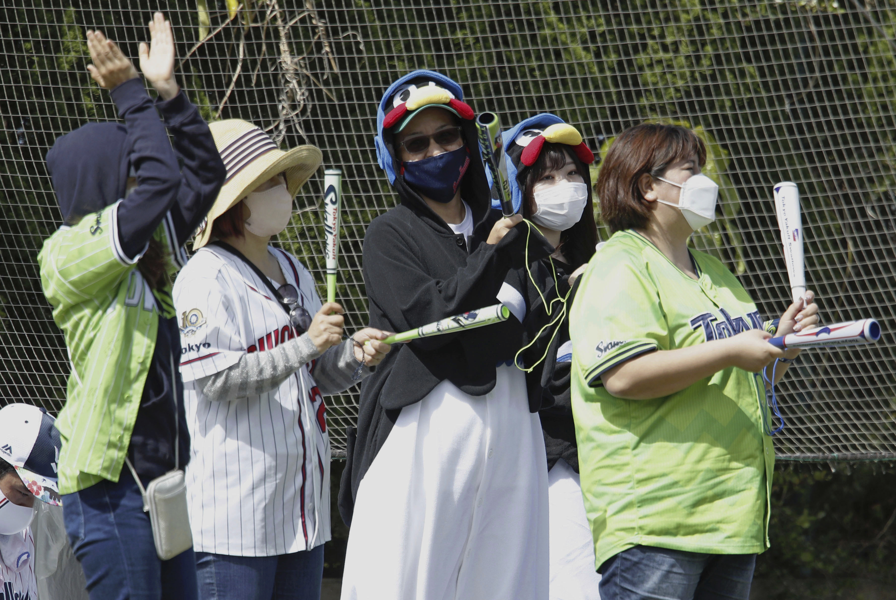 Fans for the Tokyo Yakult Swallows, a Japanese major league baseball team, cheer during the team's pre-season game against the Yomiuri Giants in Urasoe, Okinawa prefecture, Japan, Thursday, Feb. 23, 2023. Fans of the upcoming World Baseball Classic are going to see two versions, depending if the games are in the United States, Taiwan, or Japan. 