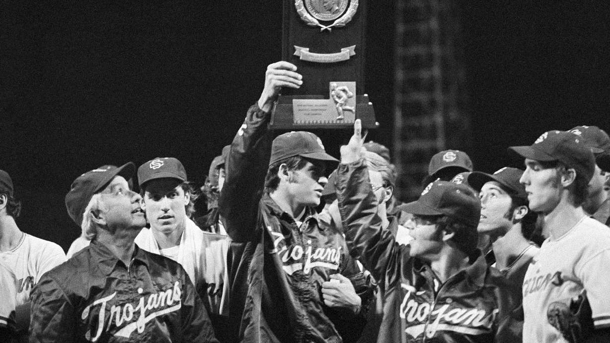 FILE - University of Southern California head coach Rod Dedeaux, left, proudly looks at the NCAA college baseball World Series trophy in Omaha, Neb., Saturday, June 15, 1974. USC defeated Miami, 7-3. Southern California has won an NCAA record 12 national championships in baseball but none since 1998. First-year coach Andy Stankiewicz is trying to pull the Trojans out of their long down cycle.