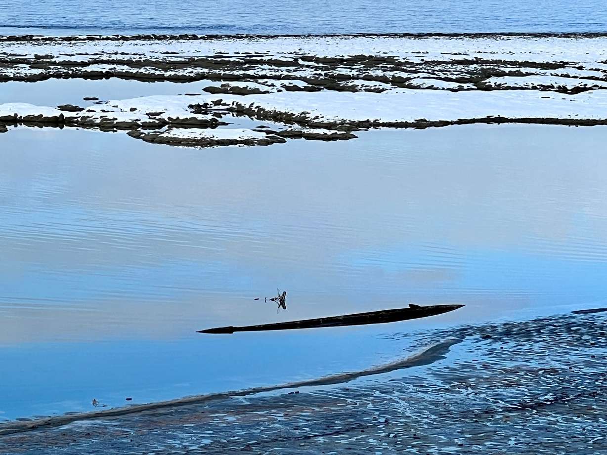 A shipwreck in Great Salt Lake is visible due to low lake levels in December 2022. Low water levels have exposed once sunken ships, including this ship that was part of the Southern Pacific Railroad fleet used to help construct and maintain the Lucin Cutoff railroad trestle across the northern end of the lake.