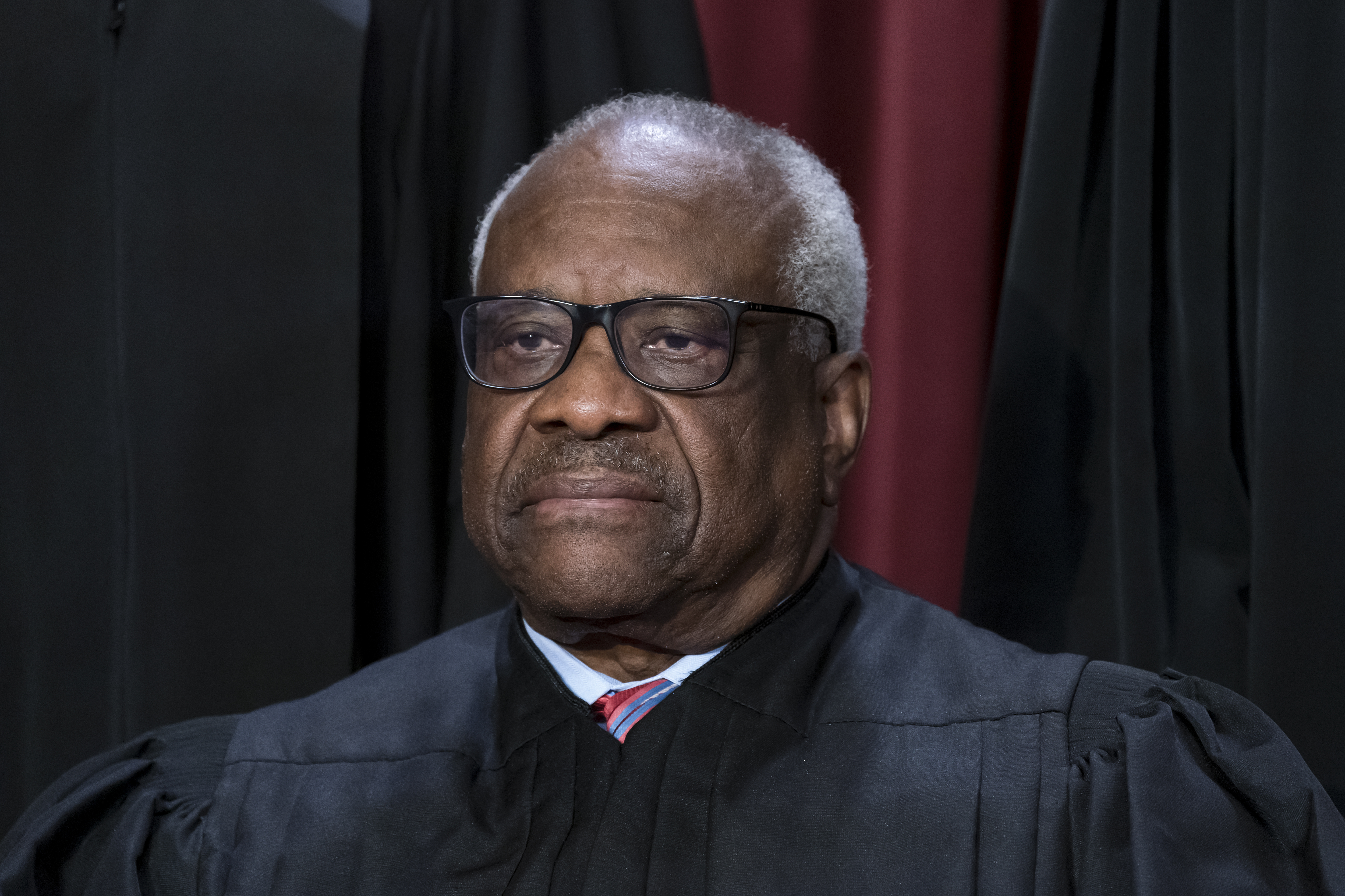Associate Justice Clarence Thomas poses in Washington, Oct. 7, 2022. The Supreme Court won’t have far to look for a personal take on the “crushing weight” of student debt that underlies the Biden administration’s college loan forgiveness plan.