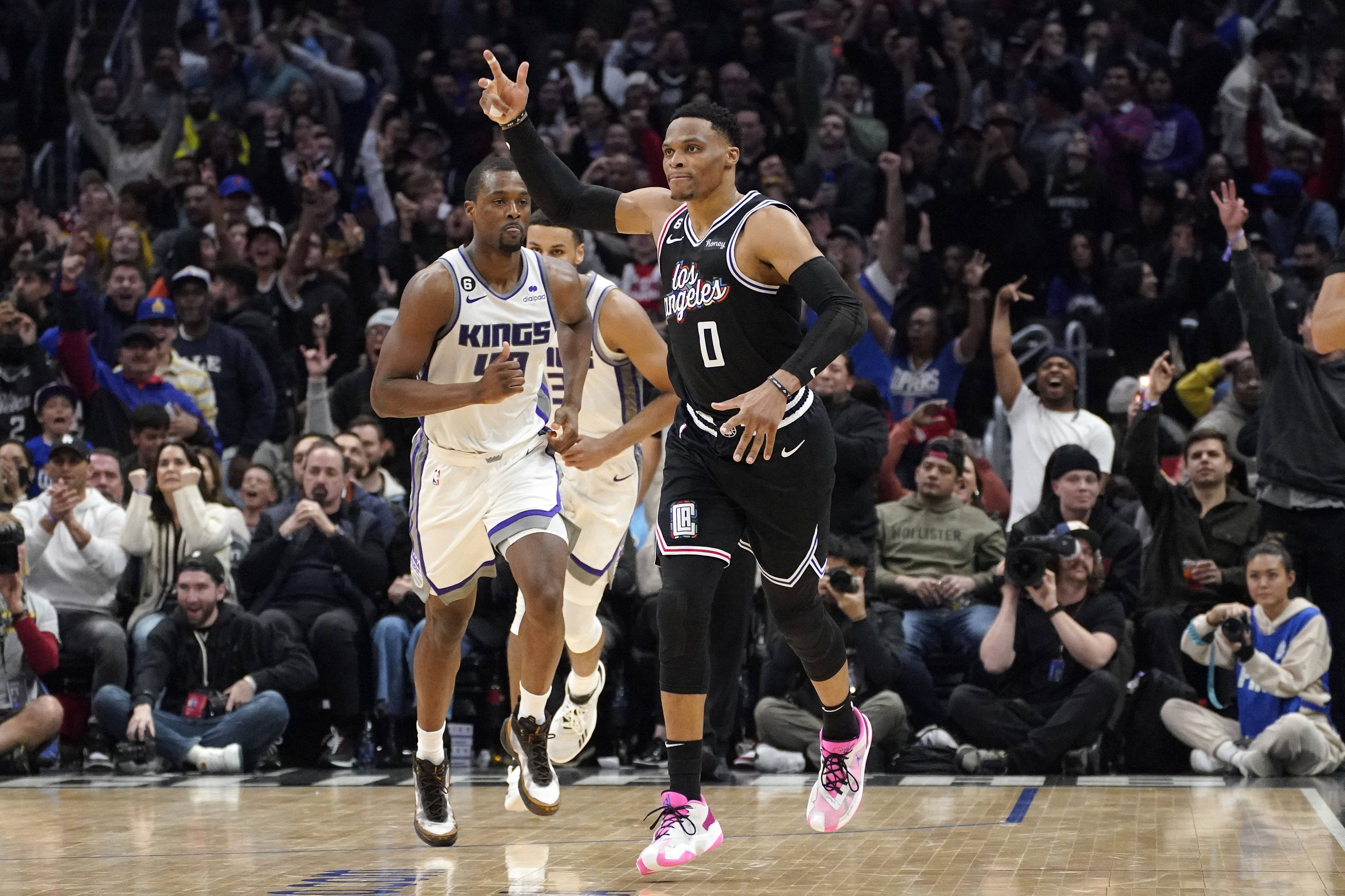 Los Angeles Clippers guard Russell Westbrook, right, celebrates after scoring as Sacramento Kings forward Harrison Barnes runs behind during the second half of an NBA basketball game Friday, Feb. 24, 2023, in Los Angeles.