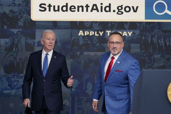 President Joe Biden answers questions with Education Secretary Miguel Cardona as they leave an event about the student debt relief portal beta test in the South Court Auditorium on the White House complex in Washington, Oct. 17, 2022. The Supreme Court is scheduled to hear arguments Tuesday, Feb. 28, 2023, involving President Joe Biden's debt relief plan that would wipe away up to $20,000 in outstanding student loans.