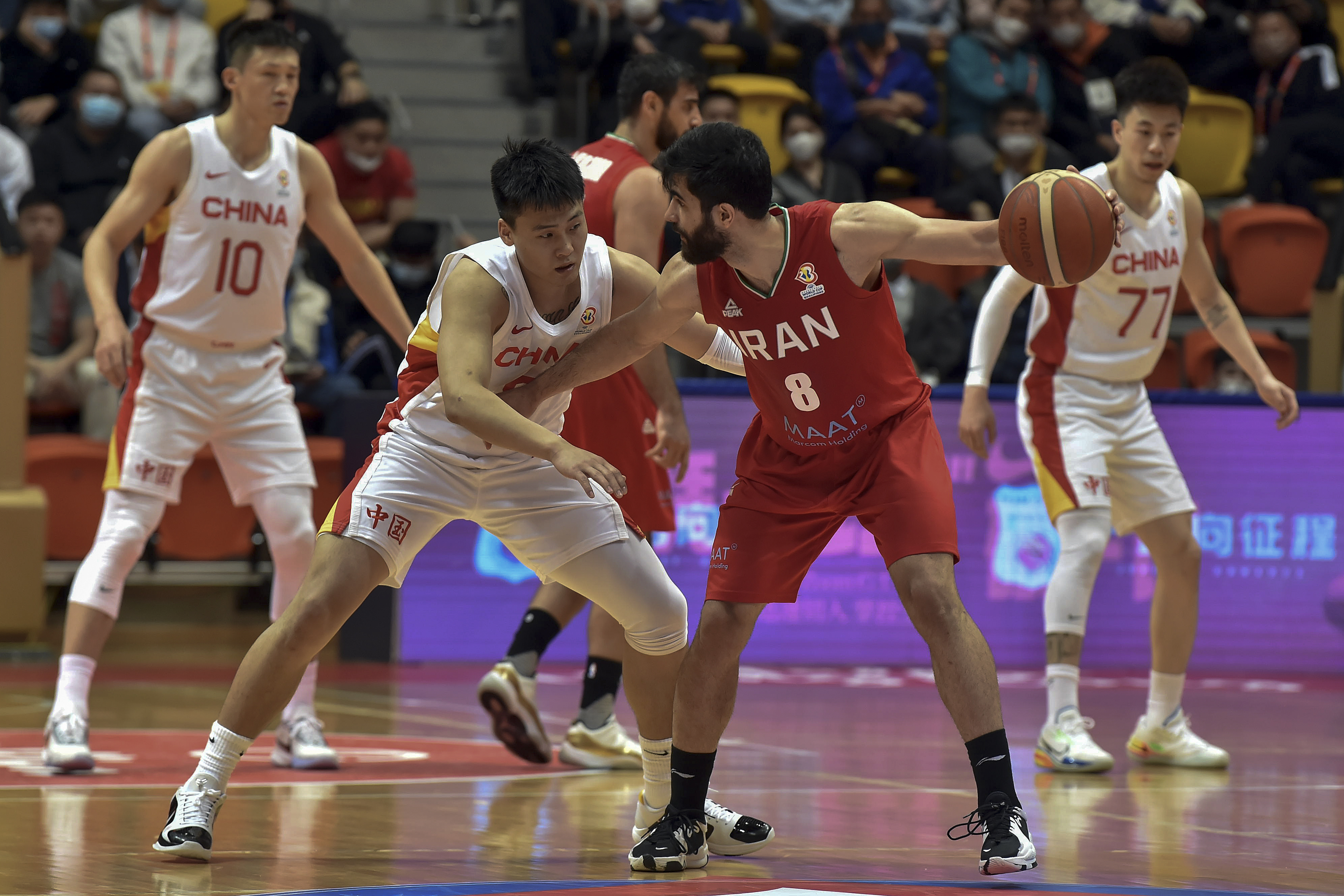 In this photo released by Xinhua News Agency, Behnam Yakhchali of Iran, right, tries to get past Zhao Rui of China during the Group F match between China and Iran in the FIBA Basketball World Cup Asian Qualifiers in Hong Kong, Sunday, Feb. 26, 2023. Iran has clinched Asia's final qualifying spot for the basketball World Cup despite losing its final playoff game 86-74 to China on Sunday. 