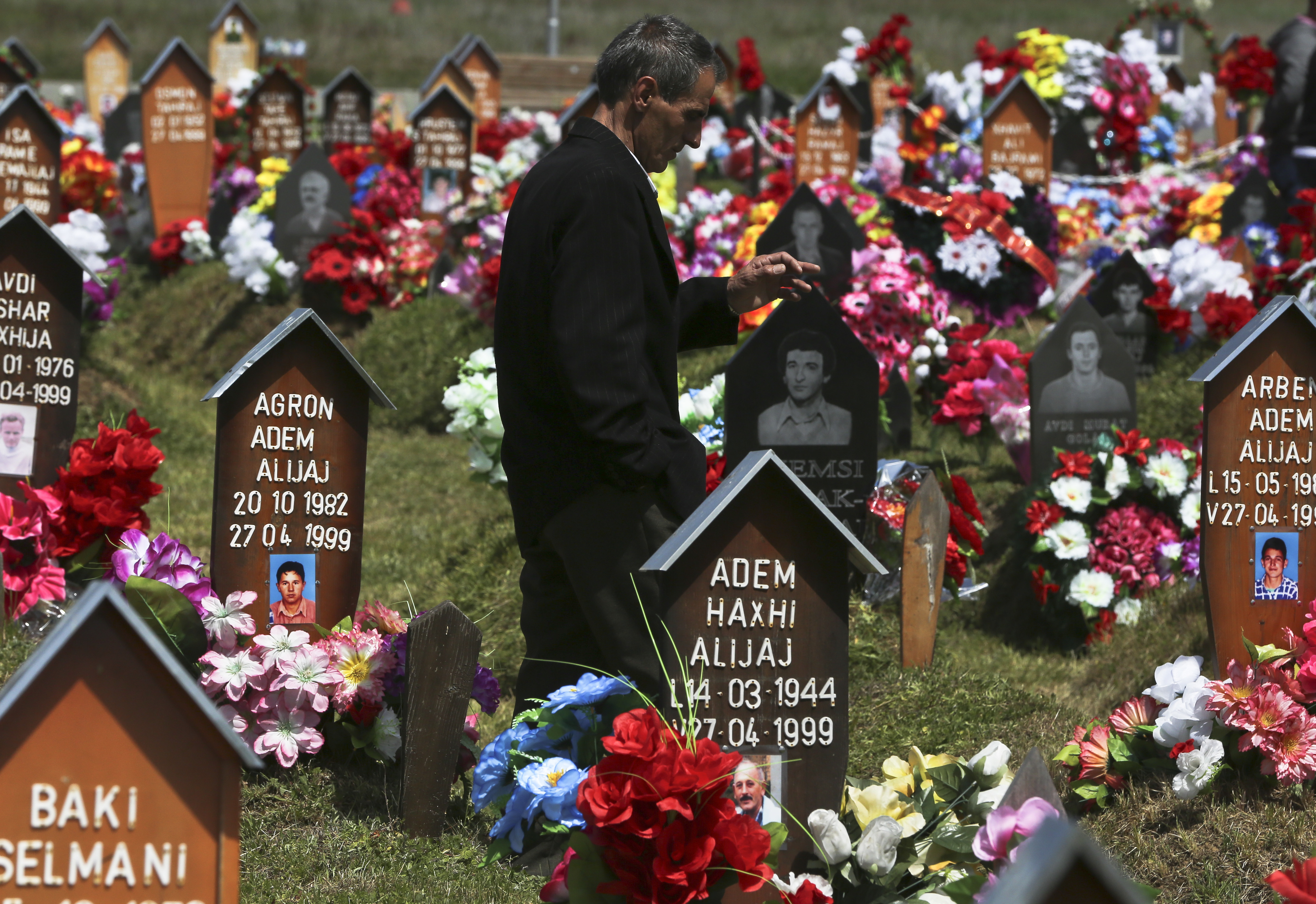 An ethnic Albanian man visits the graves of family members on April 27, 2017, near Gjakova, Kosovo, where Serb forces killed around 370 people in one day during the Kosovo's 1999 war. Around 1,600 people remain missing as a result of the 1998-99 war between ethnic Albanian rebels and Serb forces.
