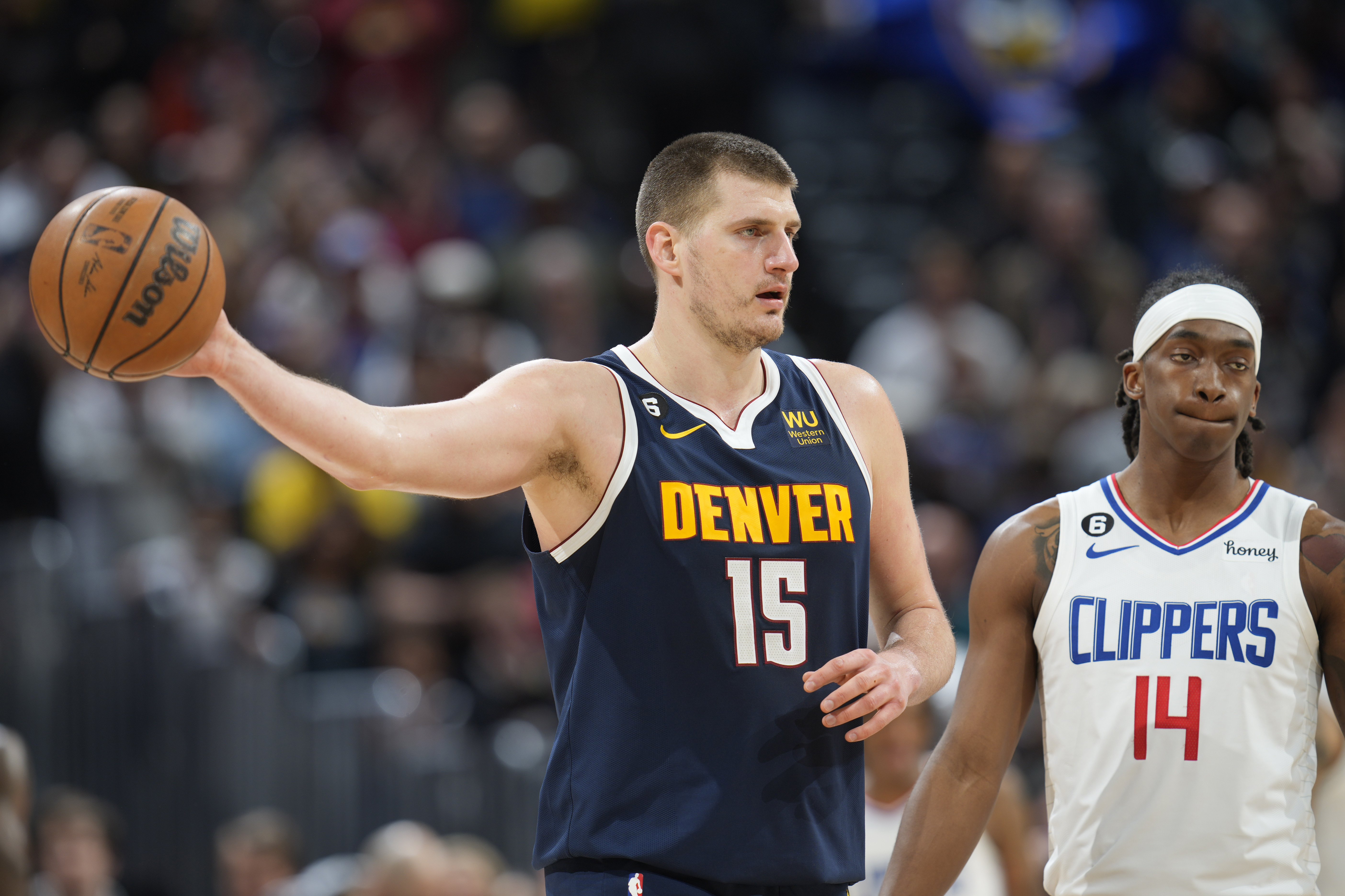 Denver Nuggets center Nikola Jokic holds on to the ball as time runs out in overtime of an NBA basketball game as Los Angeles Clippers guard Terance Mann reacts Sunday, Feb. 26, 2023, in Denver. 