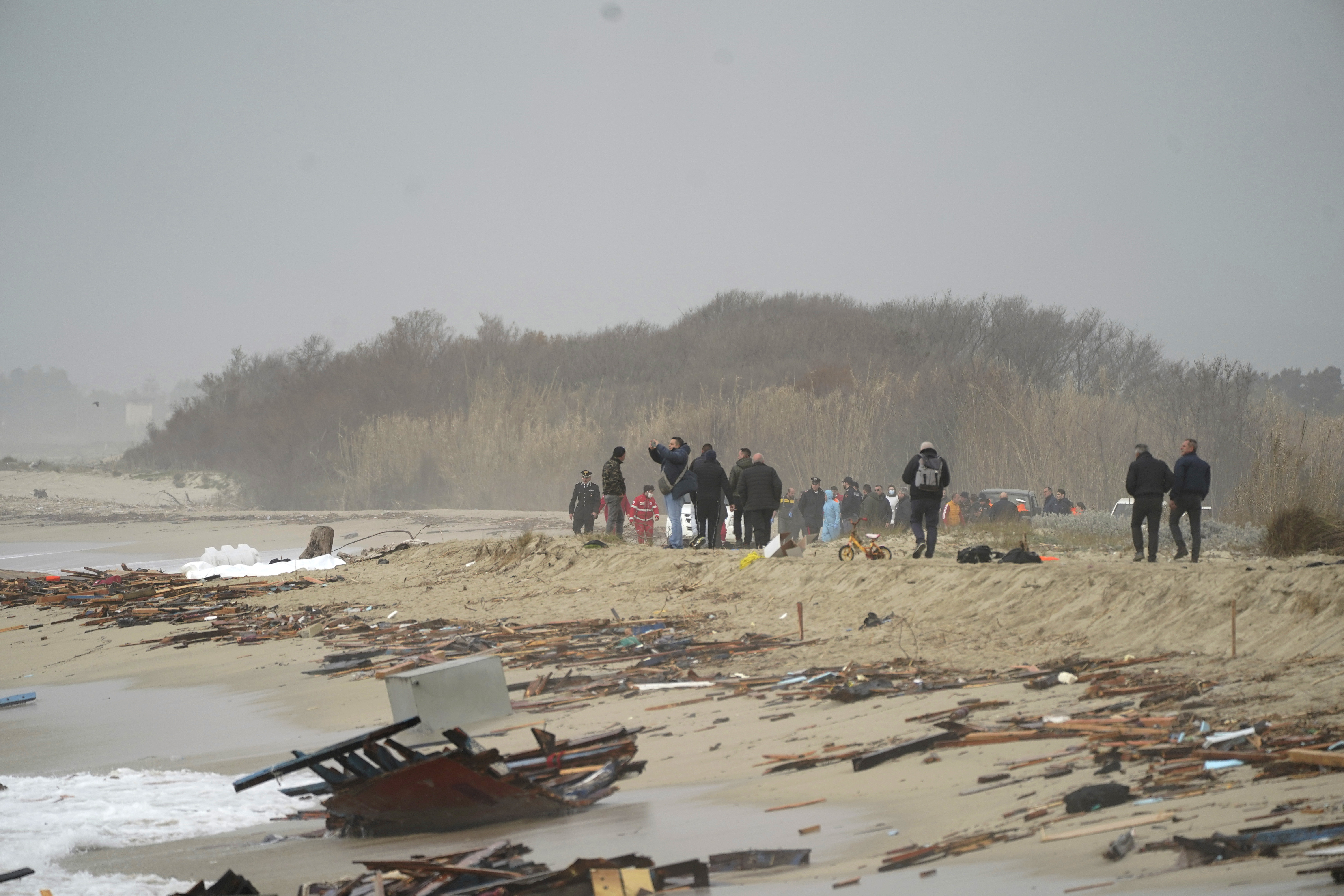 The wreckage from a capsized boat washes ashore at a beach near Cutro, southern Italy, Sunday. Rescue officials say an undetermined number of migrants have died and dozens have been rescued after their boat broke apart off southern Italy.