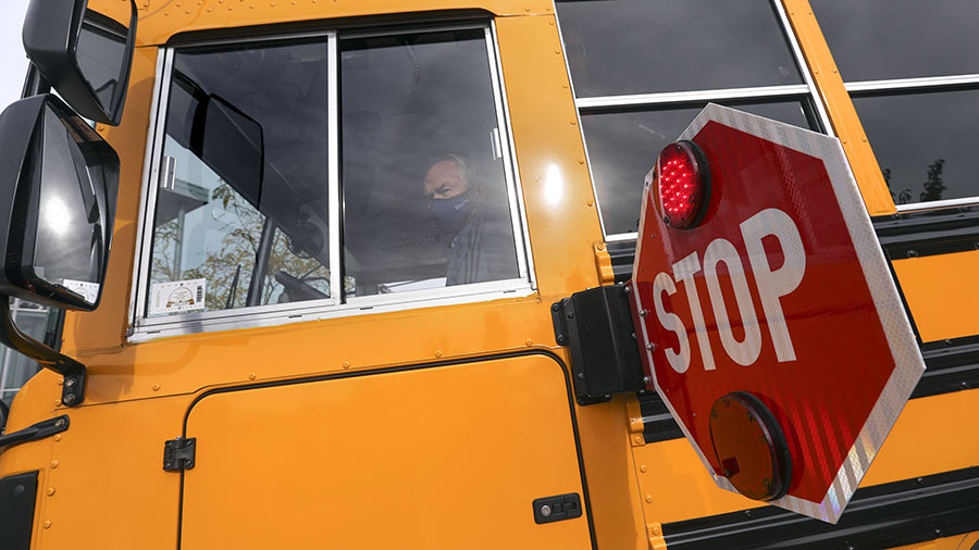A school bus driver demonstrates the use of the school bus stop sign during a press conference about school bus safety in West Valley City on Oct. 23, 2020. Three Utah school districts announced delayed start times Monday due to snow and road conditions.