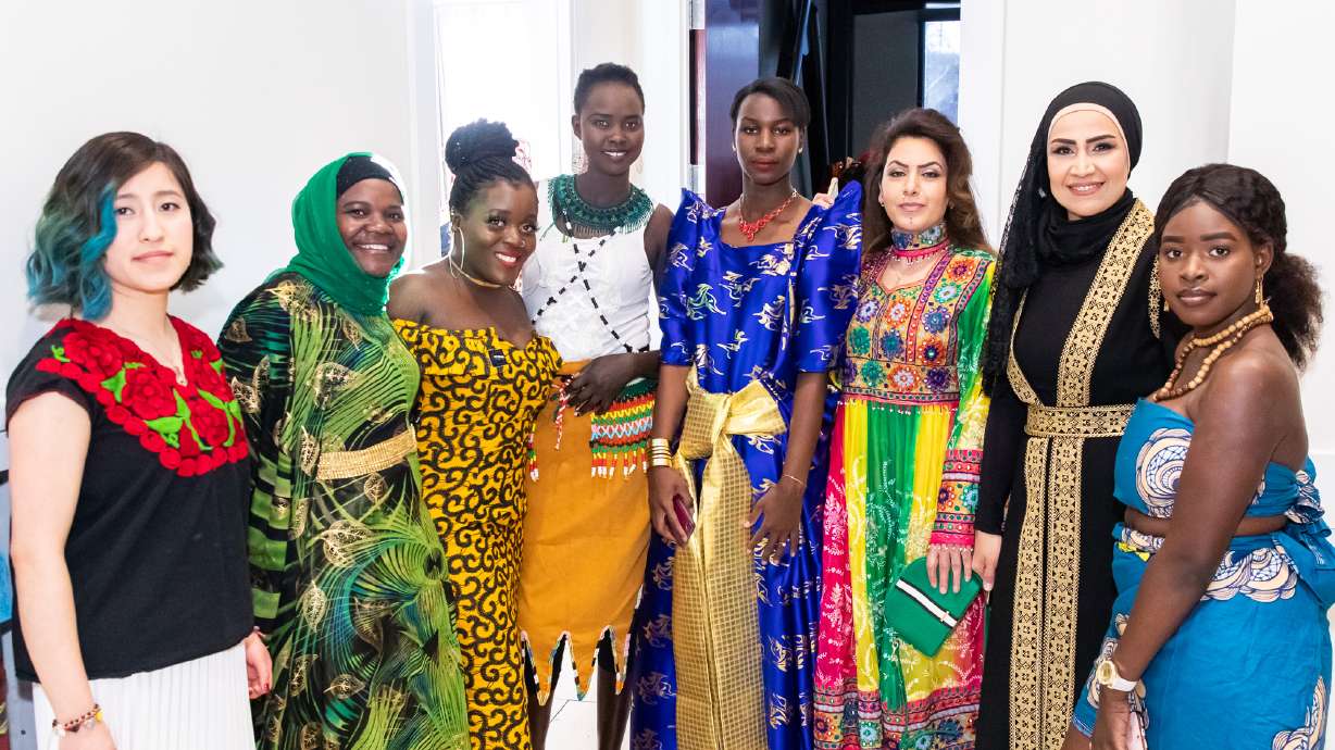 Women pose in traditional dress from their home countries at a Women of World cultural gala and fashion show. The nonprofit will hold its 13th annual fashion show in March.