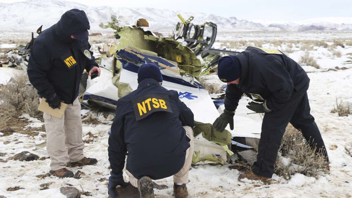 This photo provided by The National Transportation Safety Board shows NTSB investigators documenting the wreckage of a Pilatus PC-12 airplane at the crash site in Dayton, Nev., on Sunday, Feb. 26, 2023. A medical transport flight that crashed in a mountainous area in northern Nevada, killing five all five people aboard the plane including a patient, apparently broke apart before hitting the ground, authorities said Sunday.