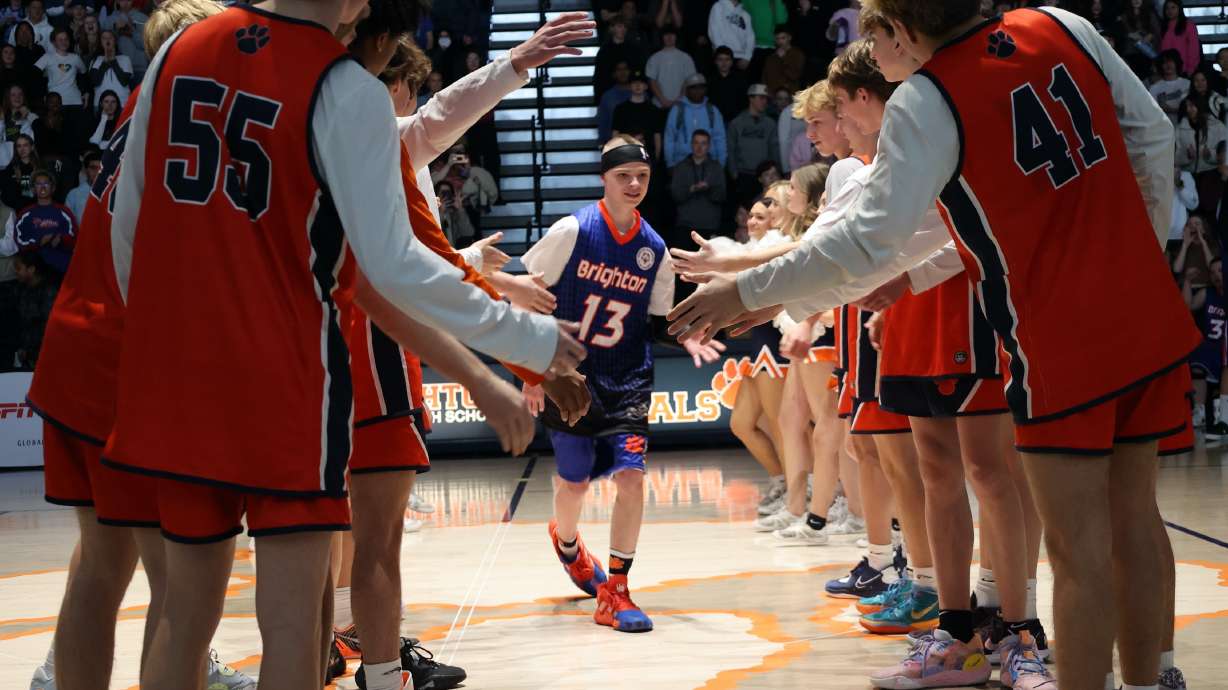 Members of the Brighton High School boys basketball team welcome starting players from the Unified Special Olympics team onto the court on Monday.