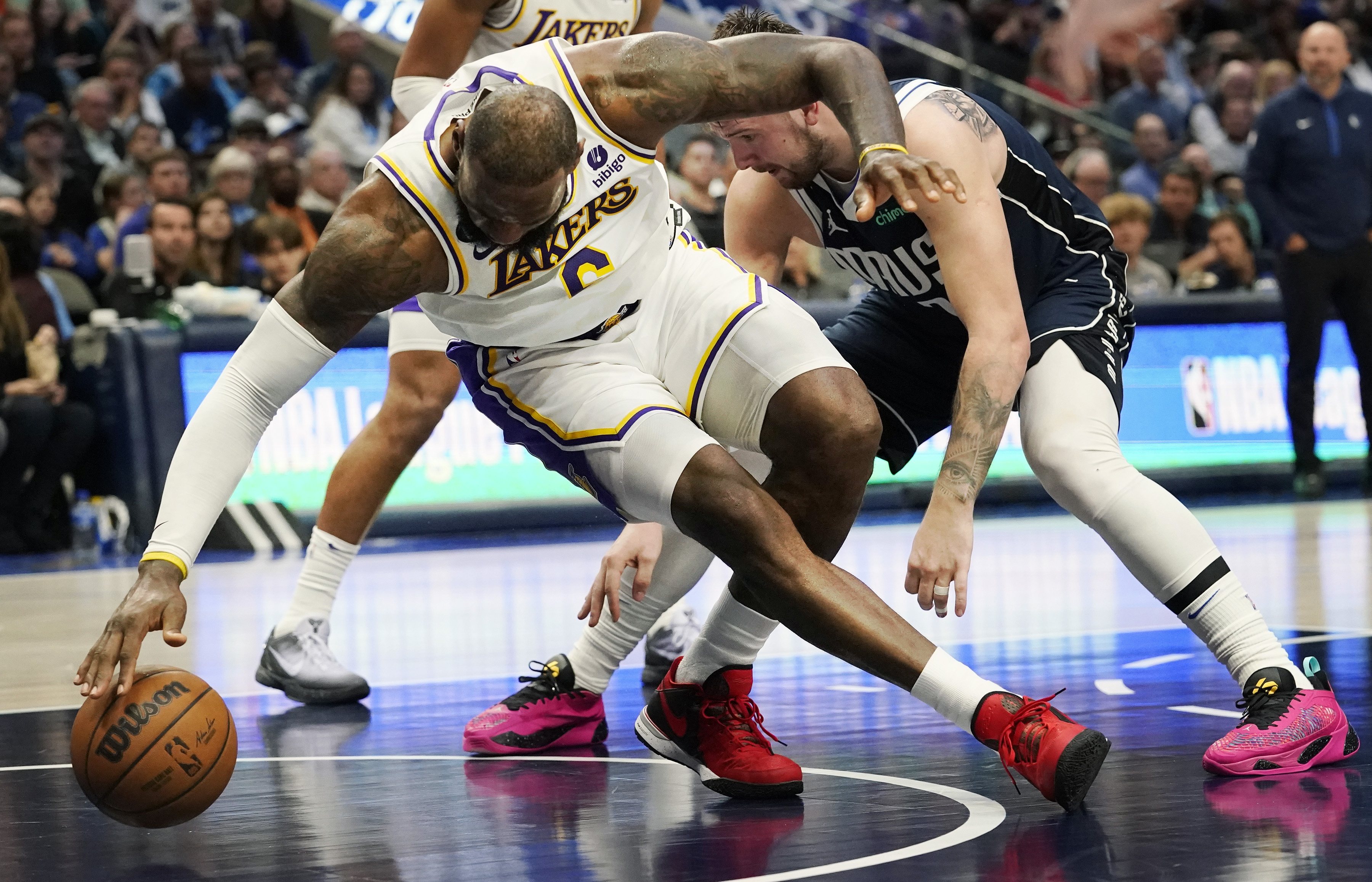 Los Angeles Lakers forward LeBron James, left, reaches for the ball against Dallas Mavericks guard Luka Doncic, right, during the second half of an NBA basketball game in Dallas, Sunday, Feb. 26, 2023.