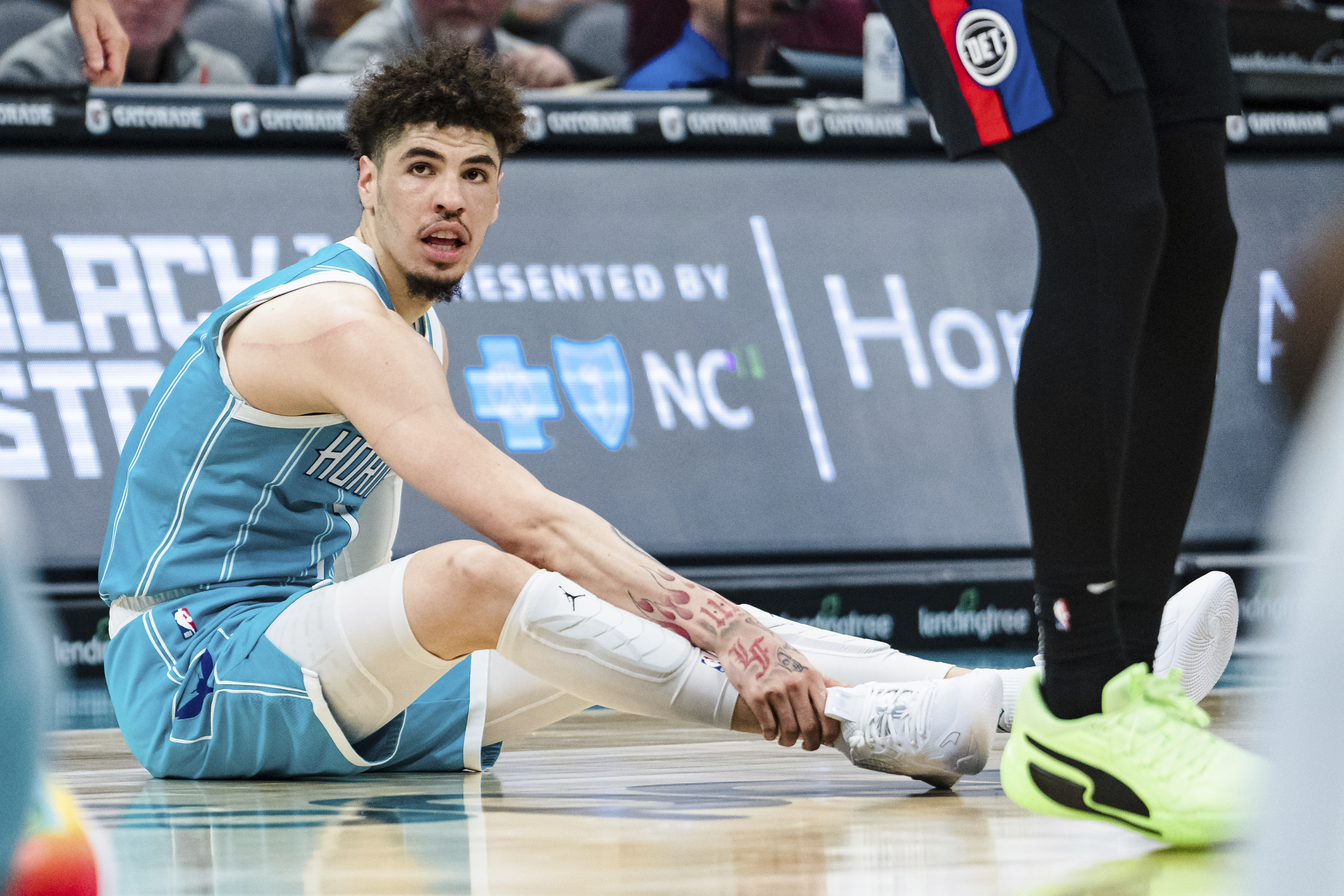 Charlotte Hornets guard LaMelo Ball holds his ankle after being shaken up on a play during the second half of an NBA basketball game against the Detroit Pistons in Charlotte, N.C., Monday, Feb. 27, 2023.