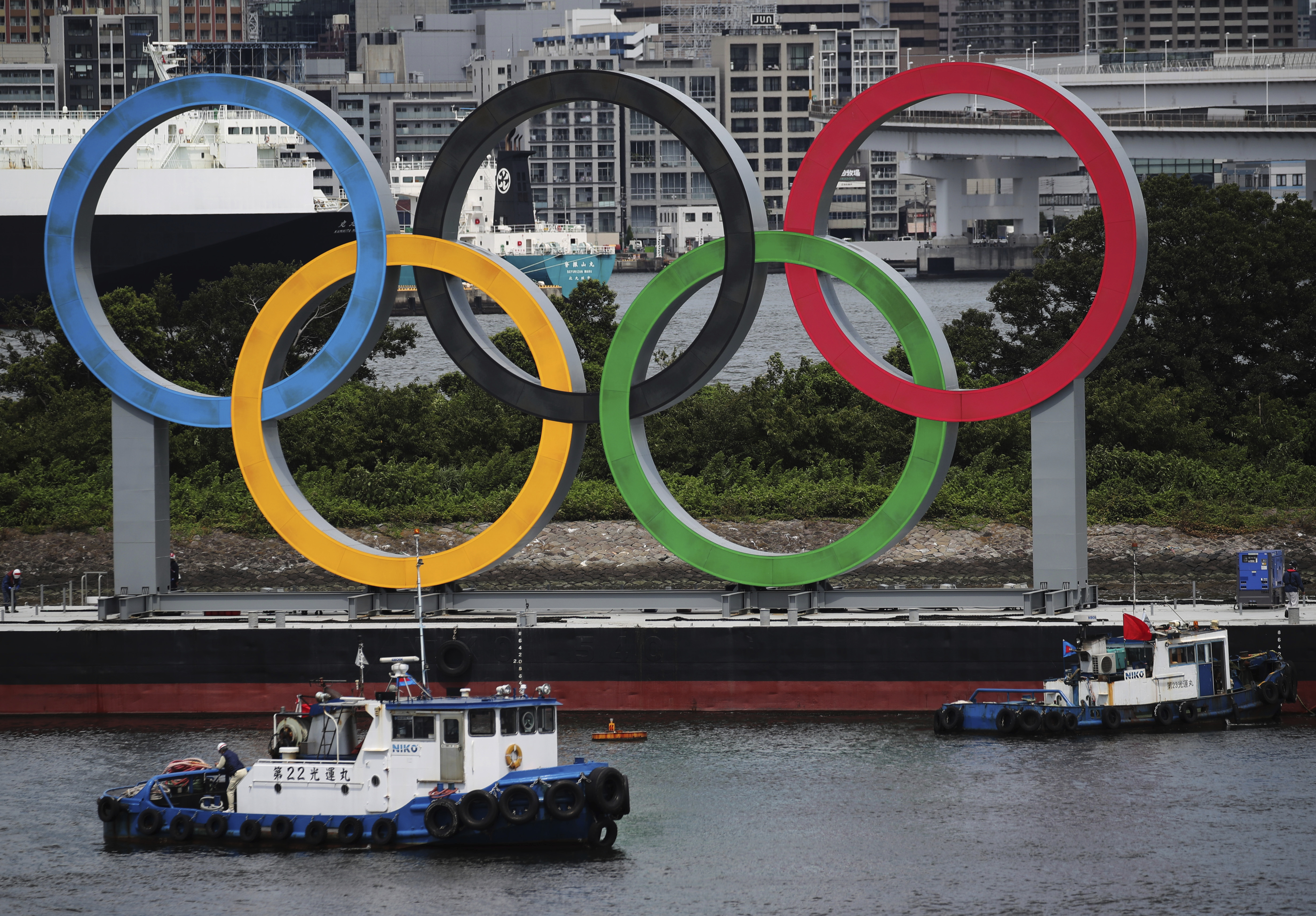 FILE - Boats prepare to tow giant Olympic rings as they are removed from the waterfront area at Odaiba Marine Park after 2020 Summer Olympics came to an end on Aug. 8 in Tokyo, Japan, Aug. 11, 2021. The Tokyo Olympic bid-rigging scandal widened Tuesday, Feb. 28, 2023, with Japanese advertising giant Dentsu and five other companies being charged by Tokyo district prosecutors. 