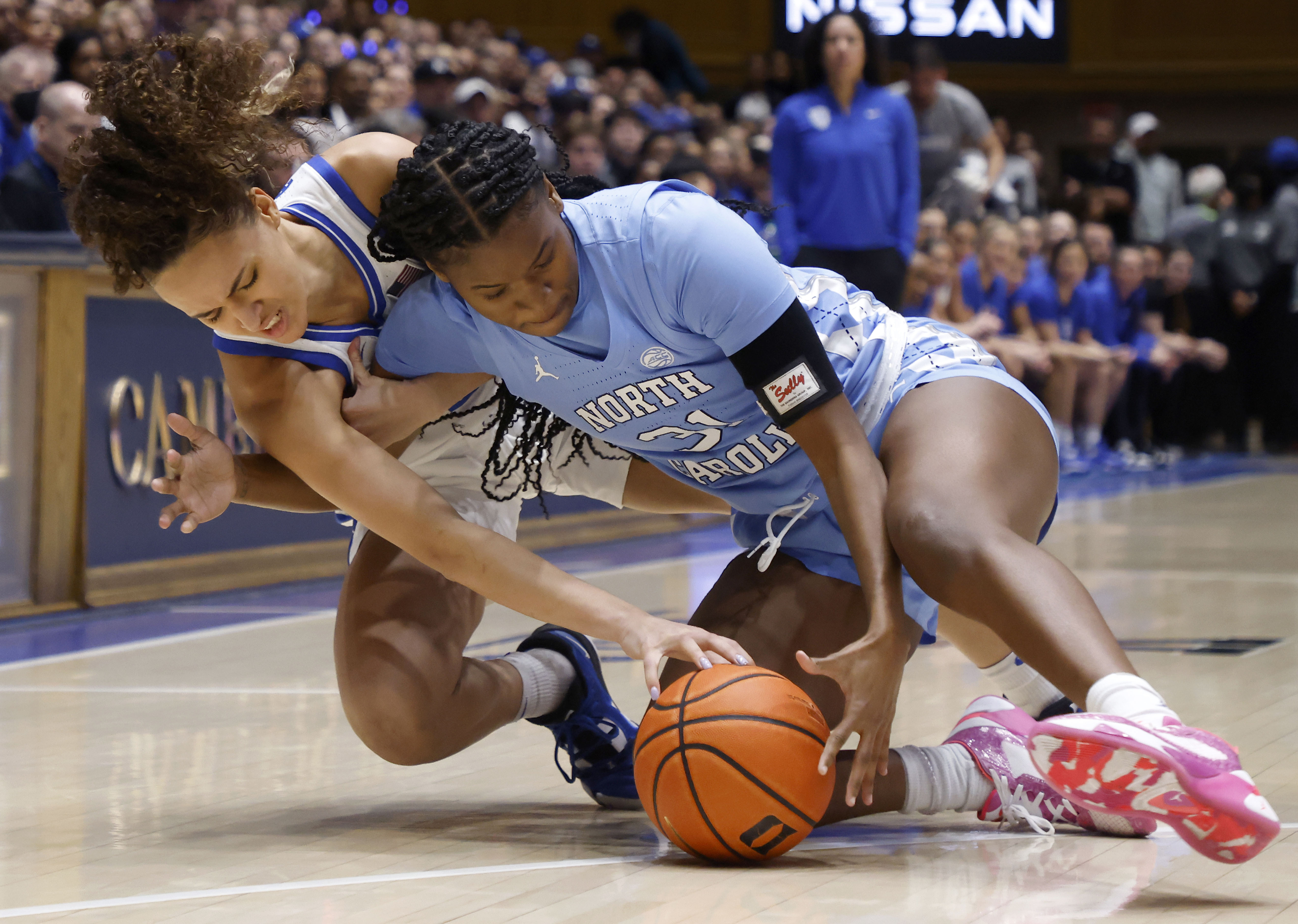 Duke's Celeste Taylor, left, and North Carolina's Anya Poole dive for the ball during the first half of an NCAA college basketball game Sunday, Feb. 26, 2023, in Durham, N.C.