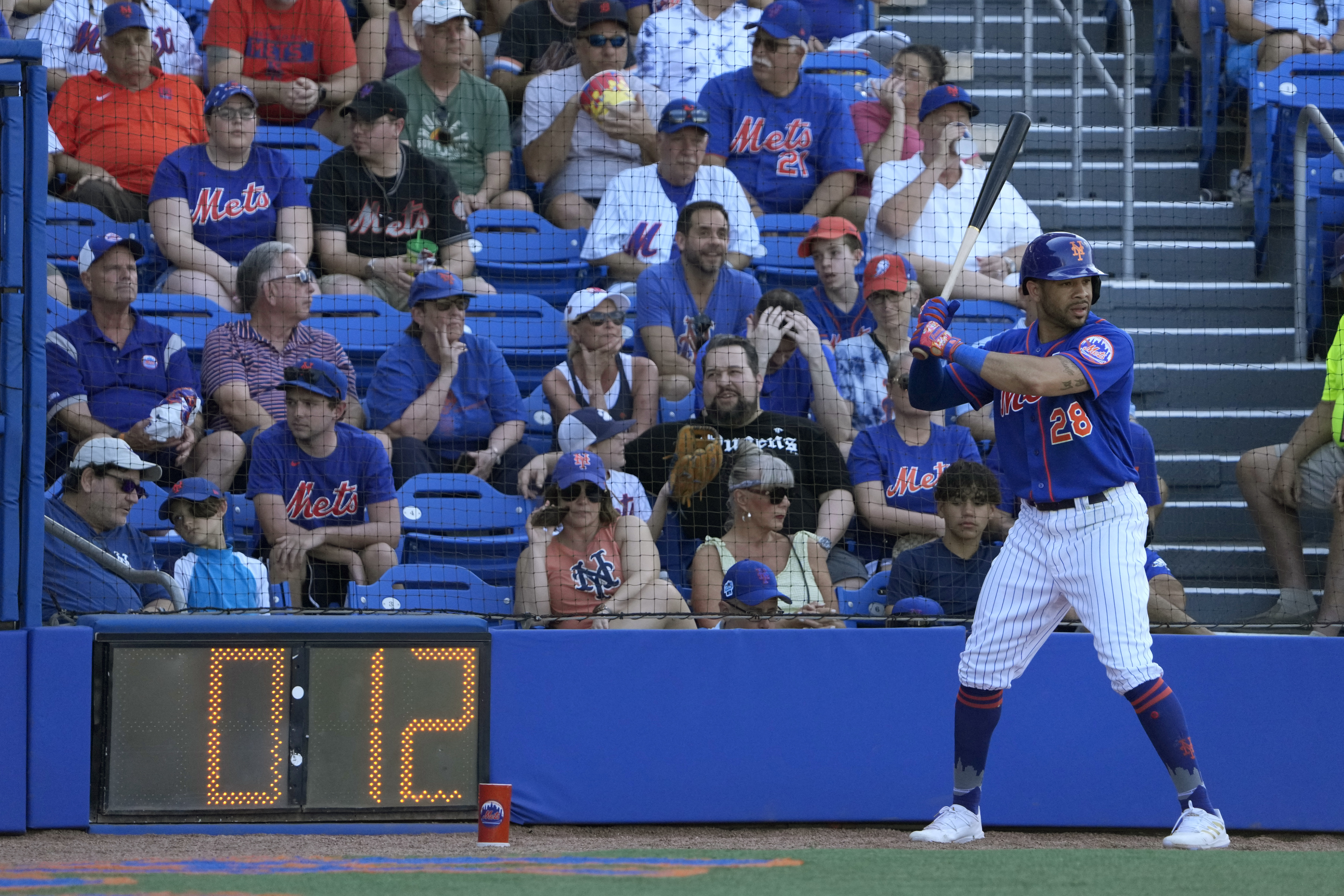 New York Mets' Tommy Pham stands in the on-deck circle as a pitch clock counts down during the sixth inning of a spring training baseball game against the Washington Nationals Sunday, Feb. 26, 2023, in Port St. Lucie, Fla. 