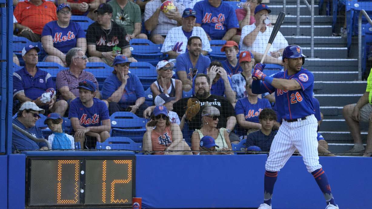 New York Mets' Tommy Pham stands in the on-deck circle as a pitch clock counts down during the sixth inning of a spring training baseball game against the Washington Nationals Sunday, Feb. 26, 2023, in Port St. Lucie, Fla.