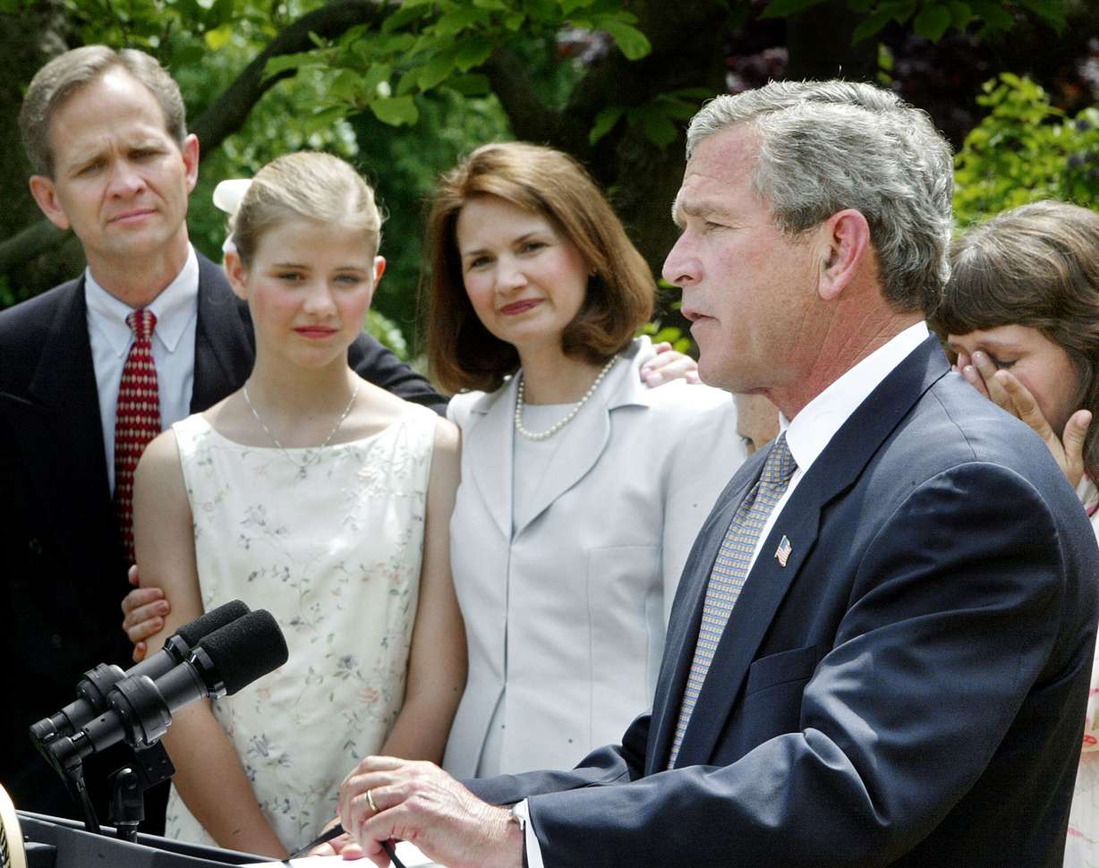 President George W. Bush speaks before signing a wide-ranging package of child safety measures in the Rose Garden of the White House on April 30, 2003, in Washington. With Bush on stage are the Smart family, left to right, Ed Smart, Elizabeth Smart, and Lois Smart.