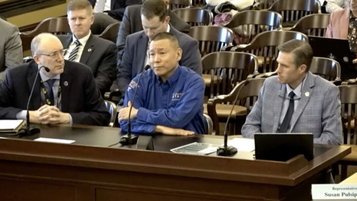 Utah Transit Authority director Jay Fox, left, and Rep. Paul Cutler, R-Centerville, right, listen during a committee meeting on Monday as UTA bus operator Neil Uemura describes an attack he suffered in December 2022.