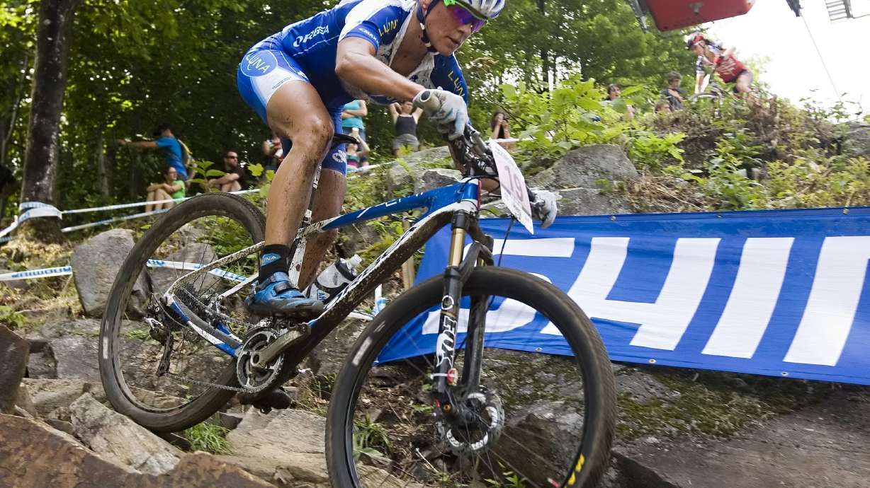 FILE - Katerina Nash, of the Czech Republic, races in the UCI women's cross country world cup on Sunday, Aug. 3, 2014, at the UCI mountain bike world cup at Mont-Sainte-Anne in Beaupre, Quebec. Katerina Nash, a cyclist and skier who represented the Czech Republic in two Winter and three Summer Olympics, avoided a four-year doping sanction after testing positive for minute traces of a banned substance. Authorities determined the substance entered her system through the skin while she was trying to give medicine drops to her ailing dog