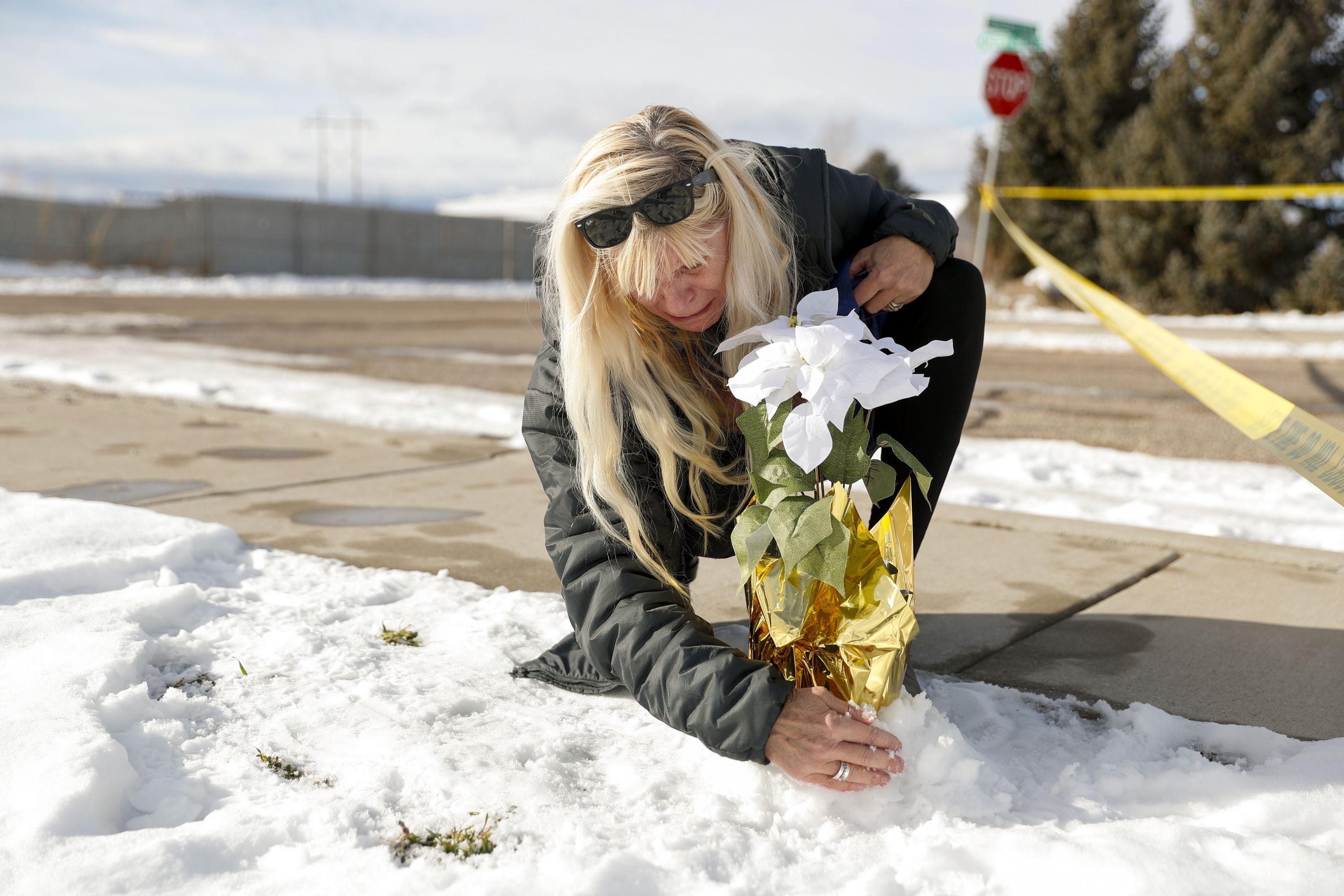 Sharon Huntsman, of Cedar City, places flowers by police tape where eight members of a family were killed in their home in Enoch, Iron County, on Jan. 5.