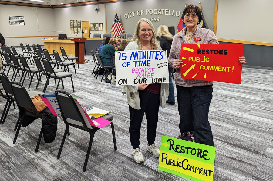 Heather Disselkoen (left) and Lydia Noble, from Pocatello for Accountable Government Entities (P.A.G.E.) holding signs inside council chambers after Thursday’s meeting.