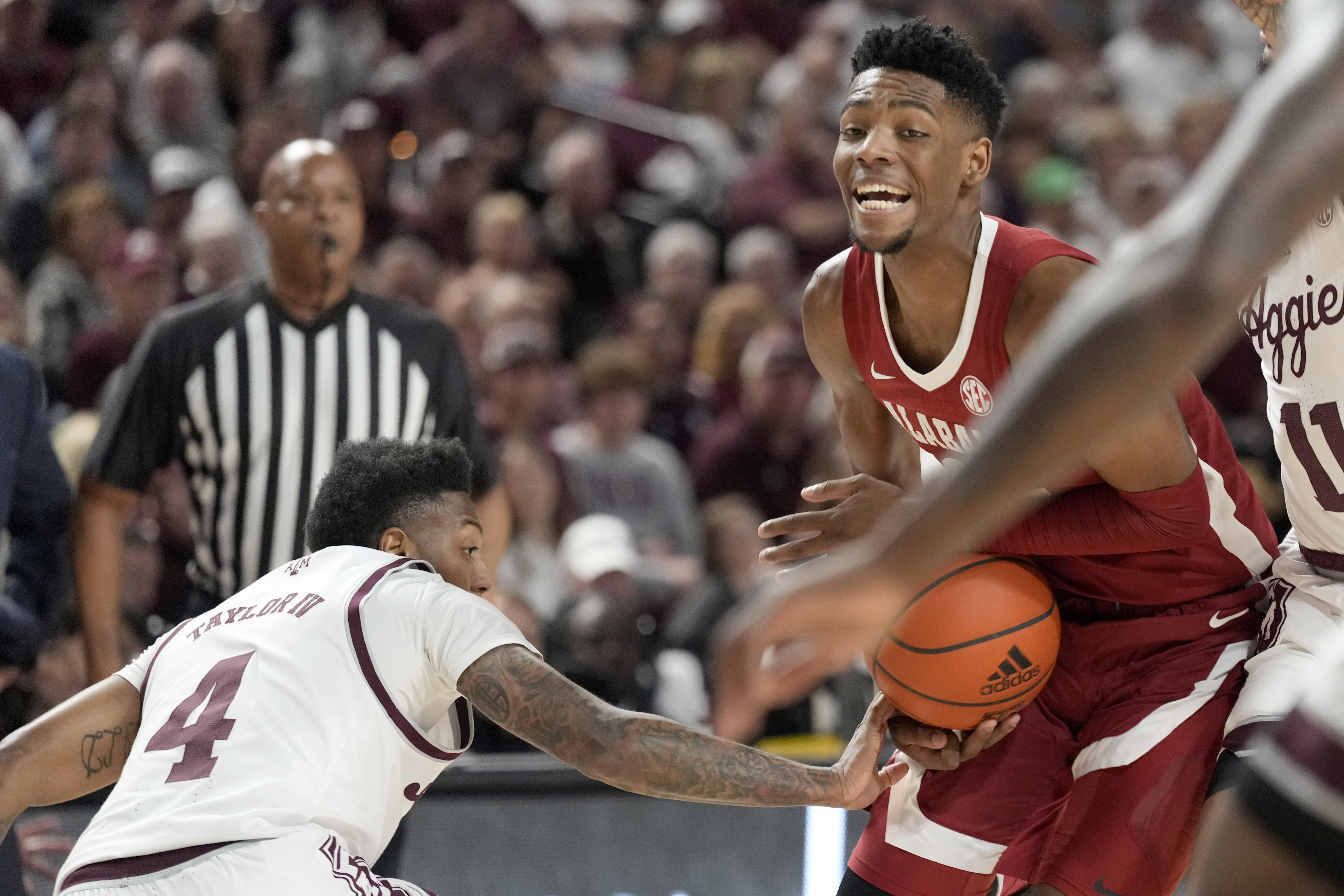 Alabama forward Brandon Miller (24) has the ball knocked away from him by Texas A&M guard Wade Taylor IV (4) while driving the lane during the first half of an NCAA college basketball game Saturday, March 4, 2023, in College Station, Texas. 