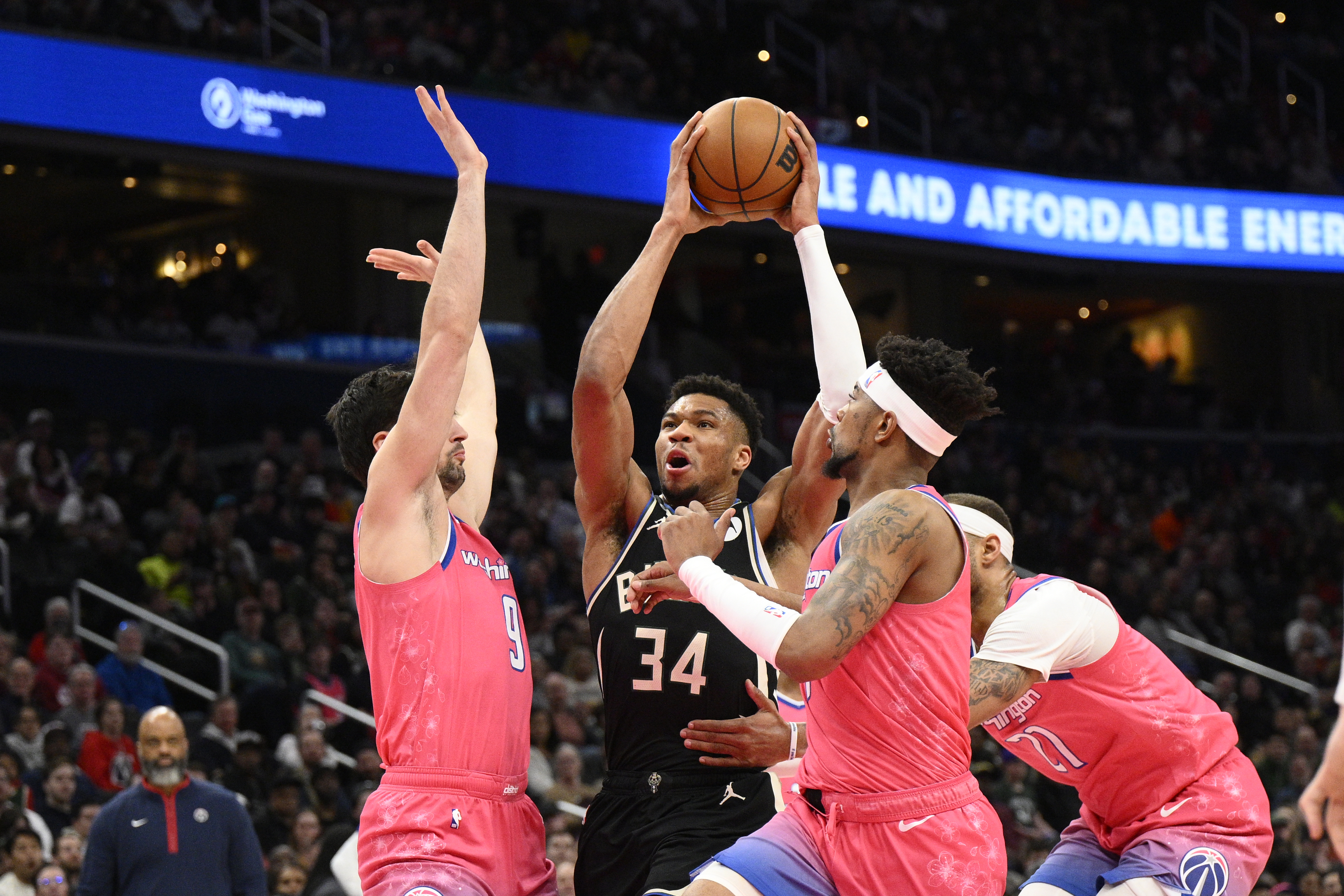 Milwaukee Bucks forward Giannis Antetokounmpo (34) goes to the basket against Washington Wizards forward Deni Avdija center Daniel Gafford and guard Jordan Goodwin during the first half of an NBA basketball game, Sunday, March 5, 2023, in Washington. Gafford was called for a foul on the play. 