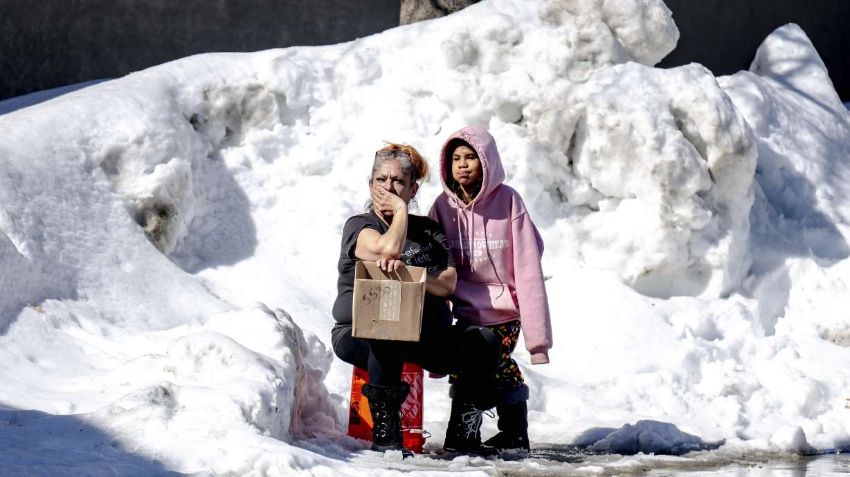 People wait for food at Goodwin & Son's Market in Crestline, Calif., Friday. Some residents remain trapped by heavy snowfall.