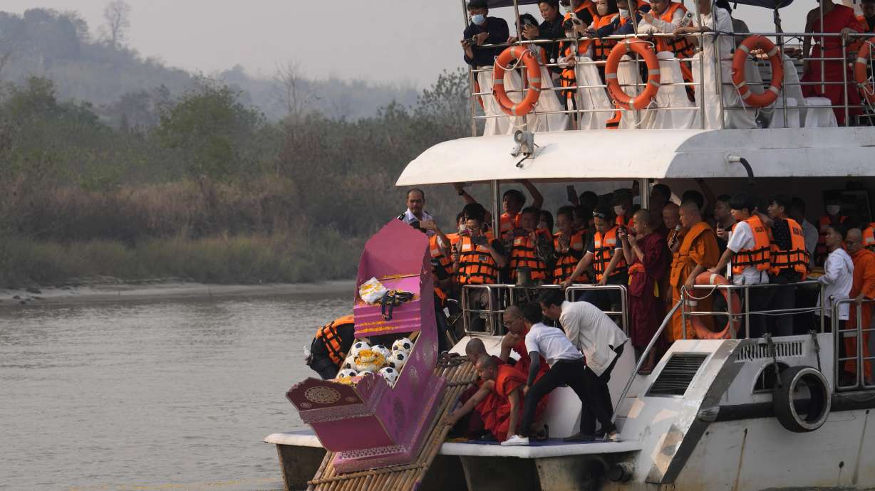 Family members, accompanied by monks and fellow mourners, release the ashes of Duangphet Phromthep in a makeshift boat along with soccer balls and some of his prized possessions into the Mekong River in Chiang Rai Province Thailand, Monday, March 6, 2023. Duangphet was one of the 12 boys rescued from a flooded cave in 2018. He died in the U.K. last month.