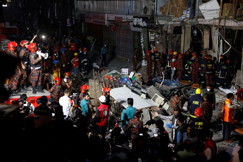Firefighters and rescue workers are seen on the site of an explosion in a multistory building in Dhaka, Bangladesh, Tuesday.