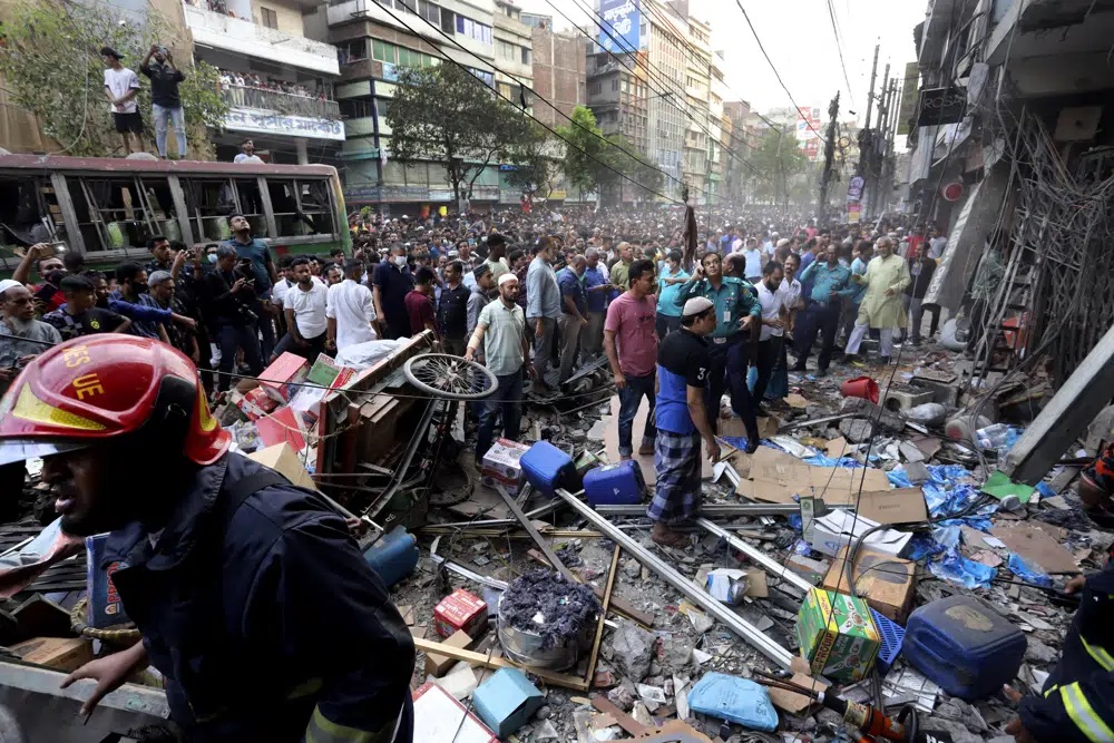 Onlookers gather outside the site of an explosion, in Dhaka, Bangladesh, Tuesday. An explosion in a seven-story commercial building in Bangladesh's capital has killed at least 14 people and injured dozens. Officials say the explosion occurred in a busy commercial area of Dhaka.