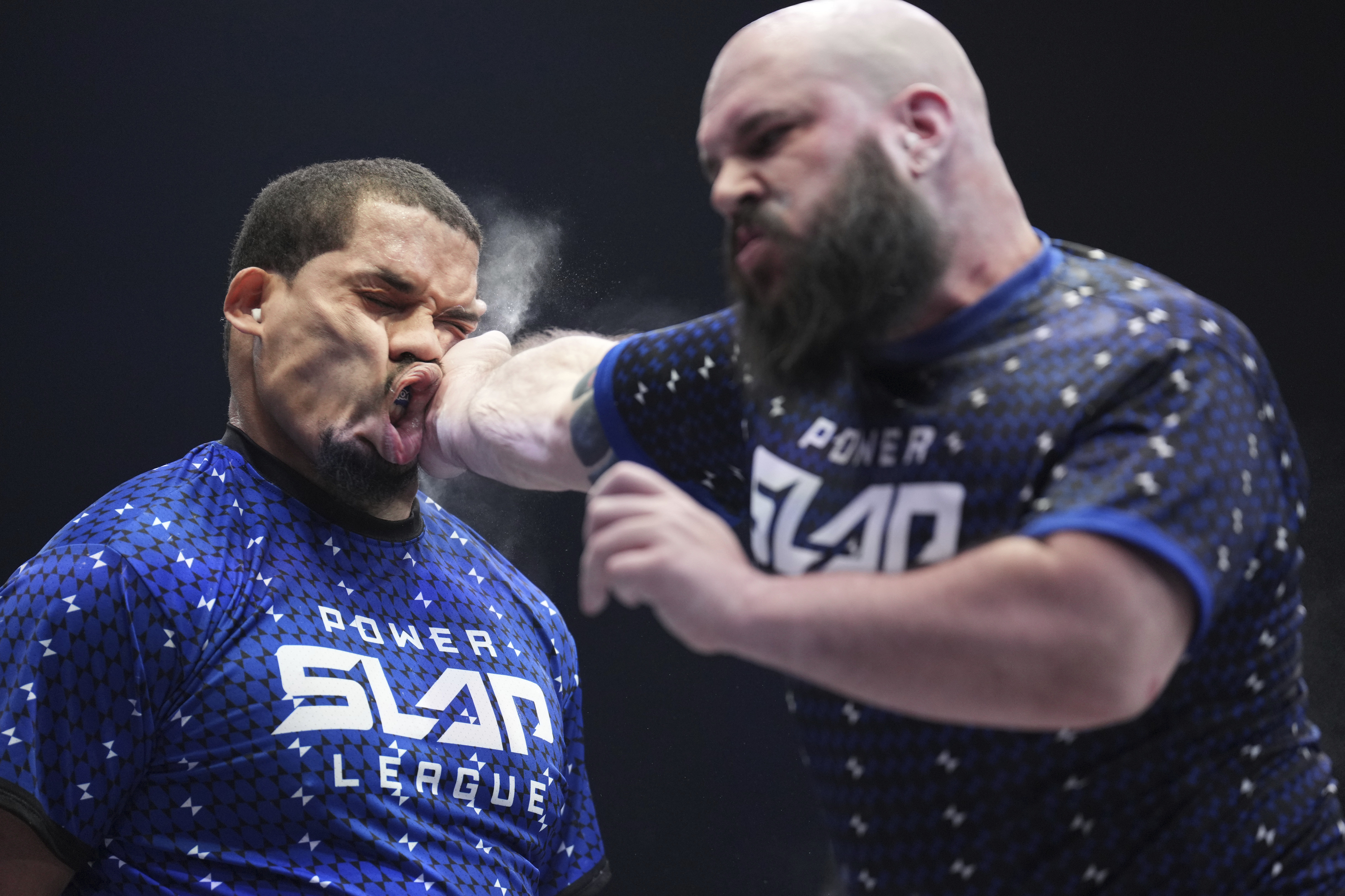 In this photo provided by Zuffa LLC, Ryan Phillips slaps Rob Perez at a Power Slap event in Las Vegas, March 31, 2022. When the open-handed blow is delivered, there's a sharp report and the reaction can be dramatic. Some fighters barely move, while others stumble backward or fall to the floor. Some are knocked out.