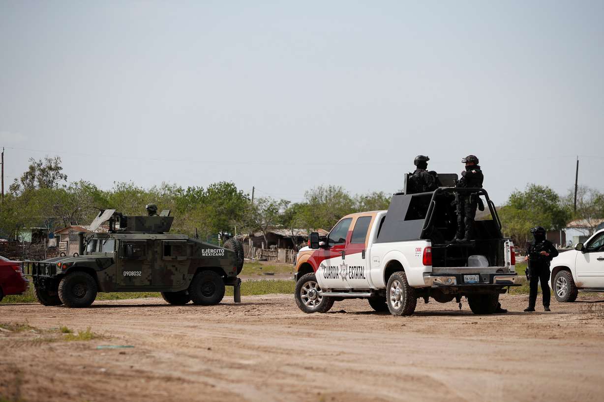 Military personnel and state police officers keep watch at the scene where authorities found the bodies of two of four Americans kidnapped by gunmen, in Matamoros, Mexico, Tuesday.
